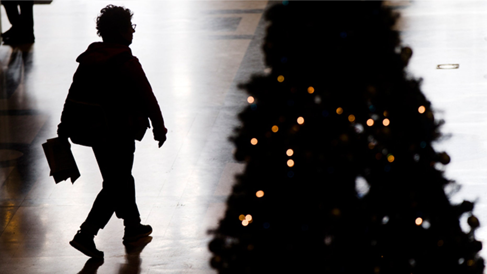 FILE -- Dec. 17, 2014: A visitor to the Free Library of Philadelphia walks through the lobby by a Christmas tree in Philadelphia.