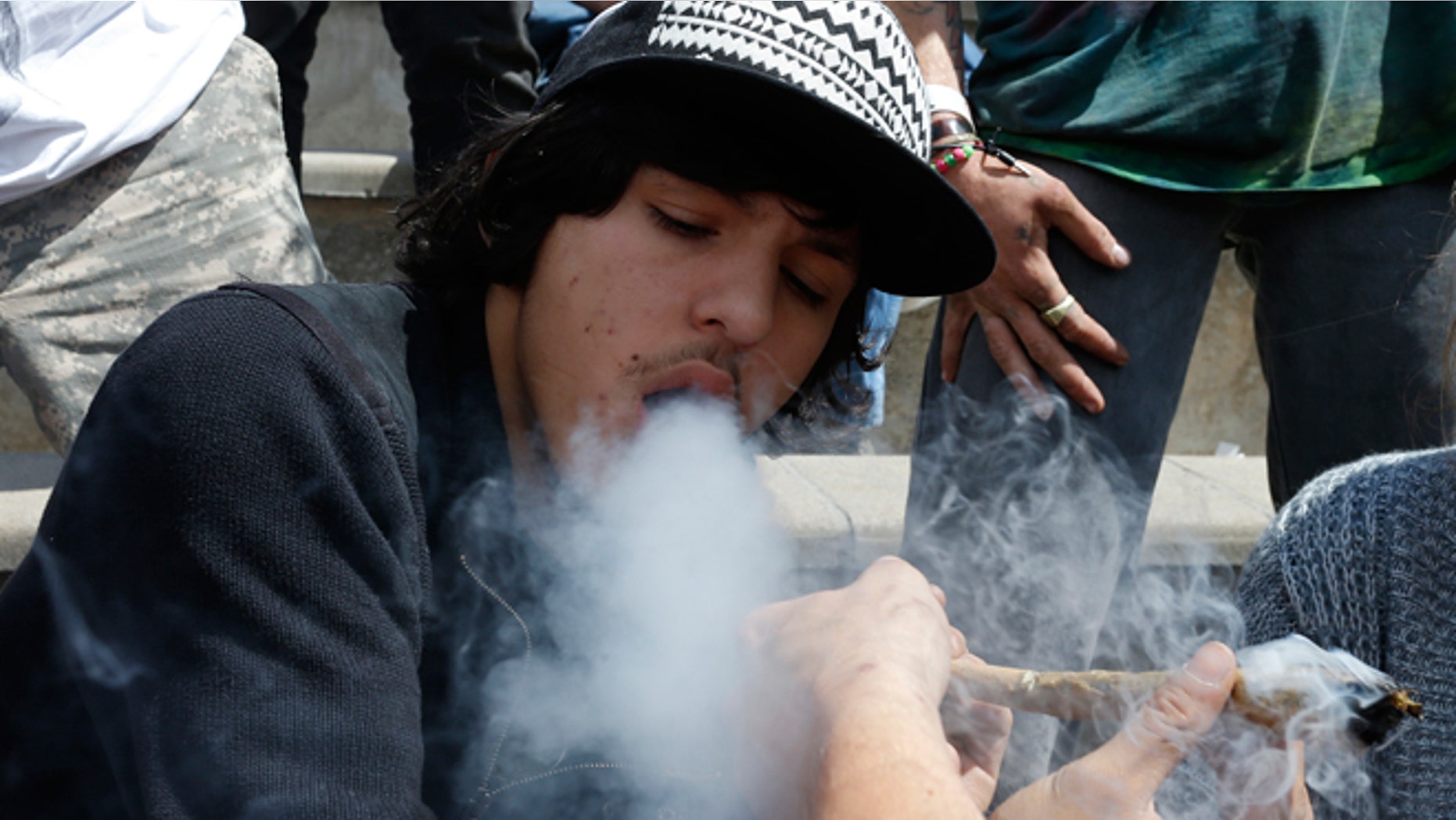 April 18, 2015: Partygoers listen to music and smoke marijuana on one of several days of the annual 4/20 marijuana festival, in Denver's downtown Civic Center Park. The annual event is the second 4/20 marijuana celebration since retail marijuana stores began selling in January 2014.