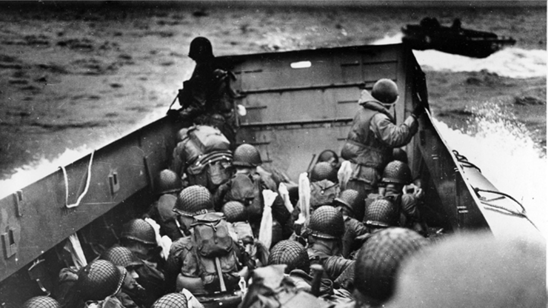 FILE - In this June 6, 2014 file photo, allied troops crouch behind the bulwarks of a landing craft as it nears Omaha Beach during a landing in Normandy, France.