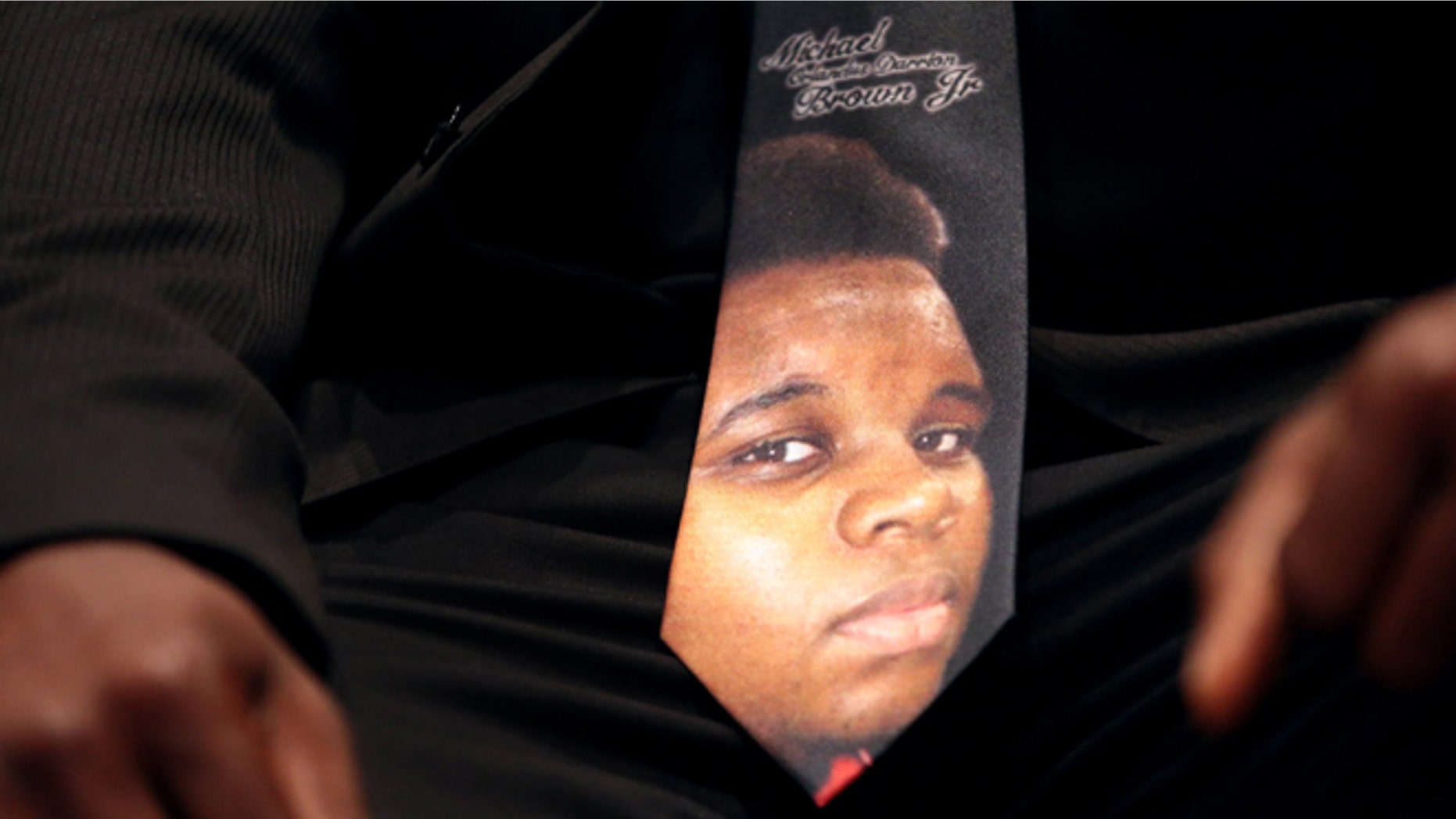 FILE - In this Aug. 25, 2014 photo, a man wears a tie decorated with a picture of Michael Brown during Brown's funeral at Friendly Temple Missionary Baptist Church in St. Louis.