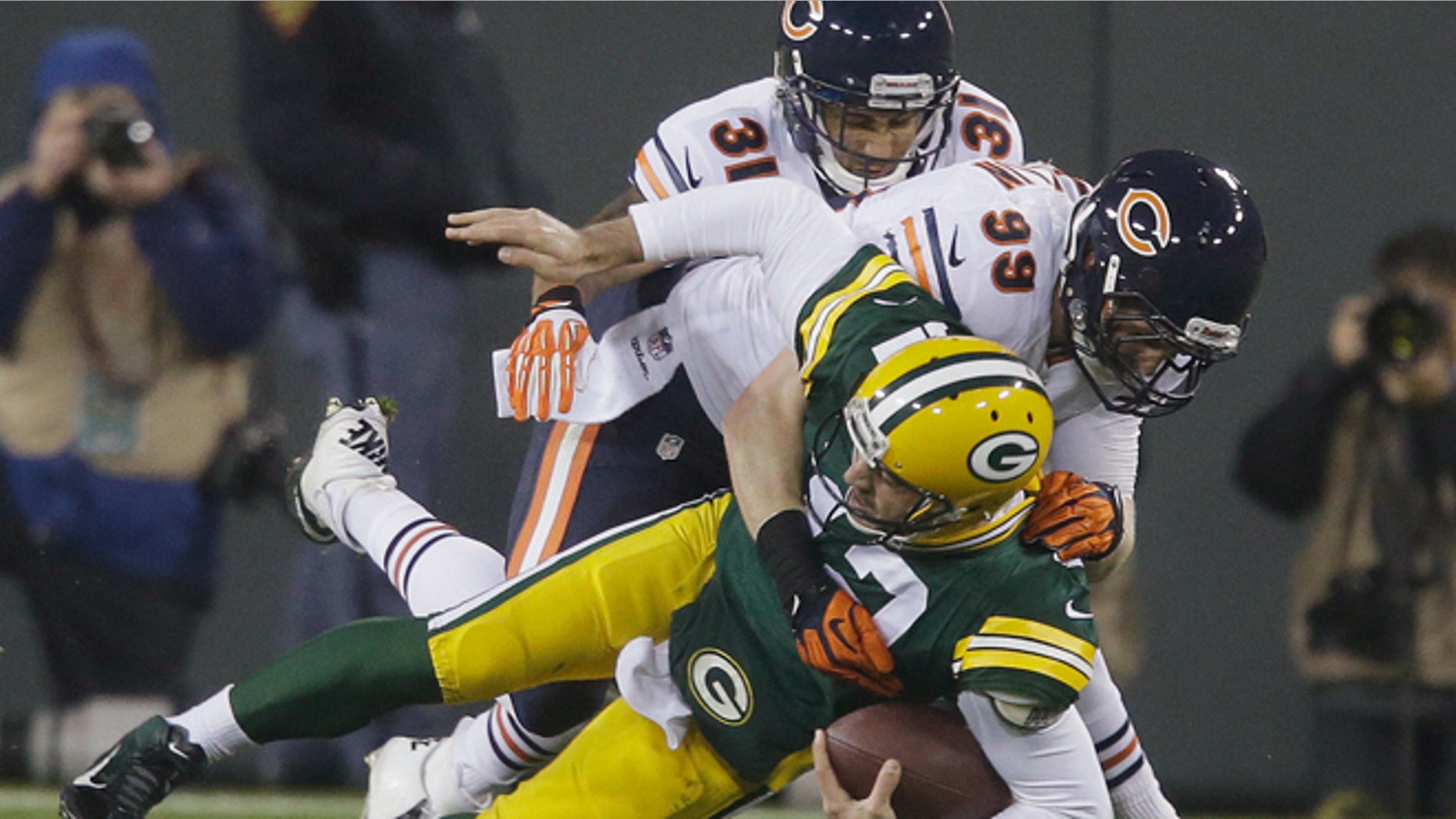FILE -- Nov. 4, 2013: Green Bay Packers quarterback Aaron Rodgers is sacked by Chicago Bears' Shea McClellin (99) and Isaiah Frey (31) during the first half of an NFL football game in Green Bay, Wis. Rodgers left the game after the play.