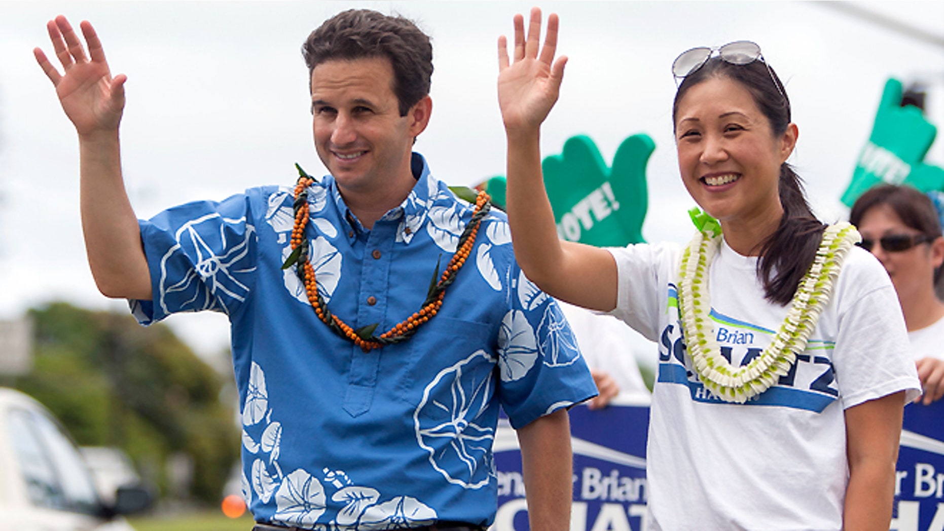 Aug. 9, 2014: U.S. Sen. Brian Schatz, left, and his wife Linda Kwok Schatz gesture to passing cars as he does some last minute campaigning before the primary, Saturday, in Honolulu. Rep. Colleen Hanabusa is challenging incumbent Schatz to determine who will fill the rest of the late Sen. Daniel Inouye's term.