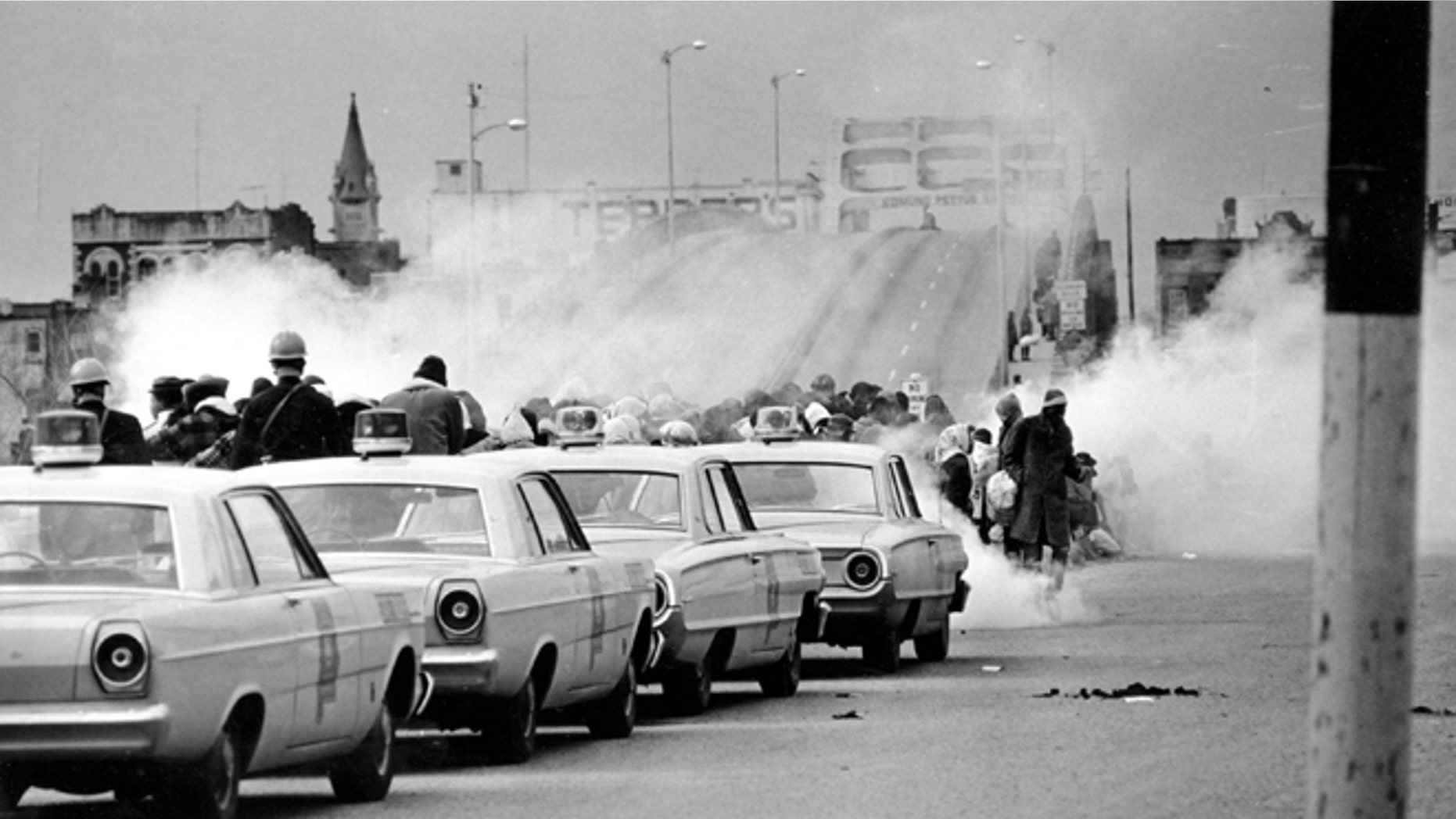 FILE - March 7, 1965: Clouds of tear gas fill the air as state troopers, ordered by Gov. George Wallace, break up a demonstration march in Selma, Ala., on what became known as "Bloody Sunday." The incident is widely credited for galvanizing the nation's leaders and ultimately yielded passage of the Voting Rights Act of 1965.