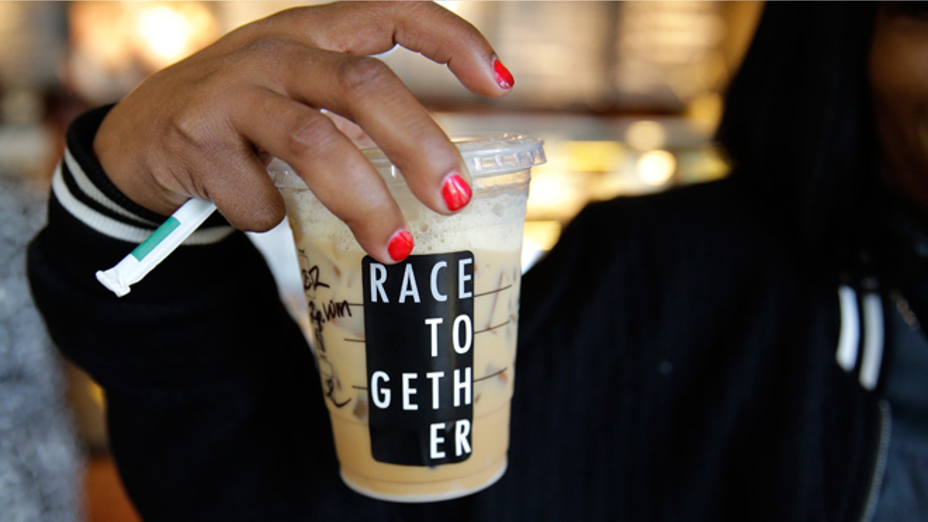 March 18, 2015: Larenda Myres holds an iced coffee drink with a "Race Together" sticker on it at a Starbucks store in Seattle. Starbucks CEO Howard Schultz announced earlier in the day at the company's annual shareholder meeting that participating baristas at stores in the U.S. will be putting the stickers on cups and also writing the words "#RaceTogether" for customers in an effort to raise awareness and discussion of race relations.