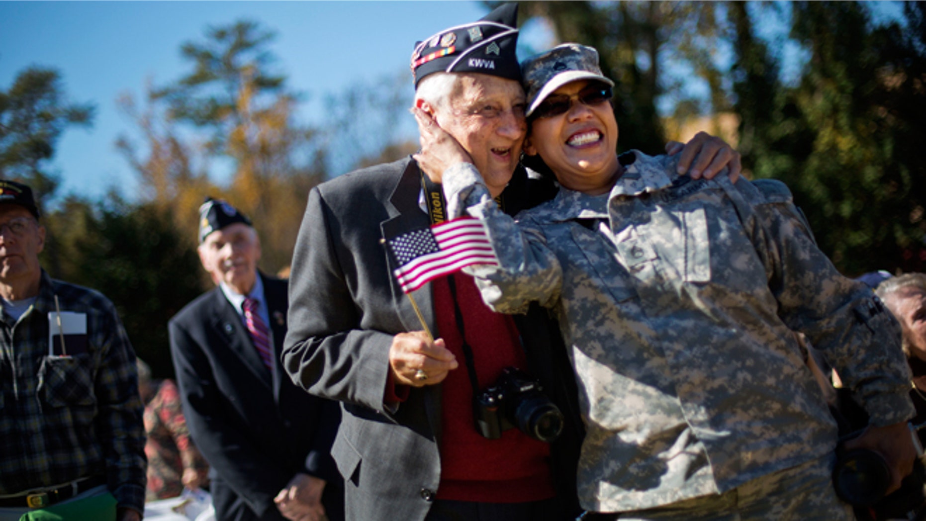 Nov. 11, 2014: U.S. Army Georgia National Guard Staff Sgt. Tracy Smith, right, a veteran of the wars in Iraq and Afghanistan, embraces Korean War veteran Jim Conway, 84, as military service members are asked to sing along to the Armed Services Medley during a Veterans Day ceremony at the Atlanta History Center.