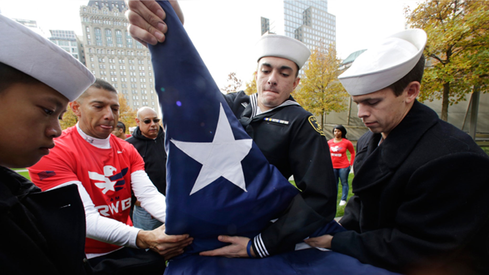 Nov. 9, 2014: Sea Cadets Daniel Cheng, left, Thomas Kessler, center, and Jack Toll help veterans advocacy group Team Red White and Blue furl a large American flag at the National September 11 Memorial in New York. The cadets are members of the John T. Dempster, Jr. Division in Trenton, N.J.