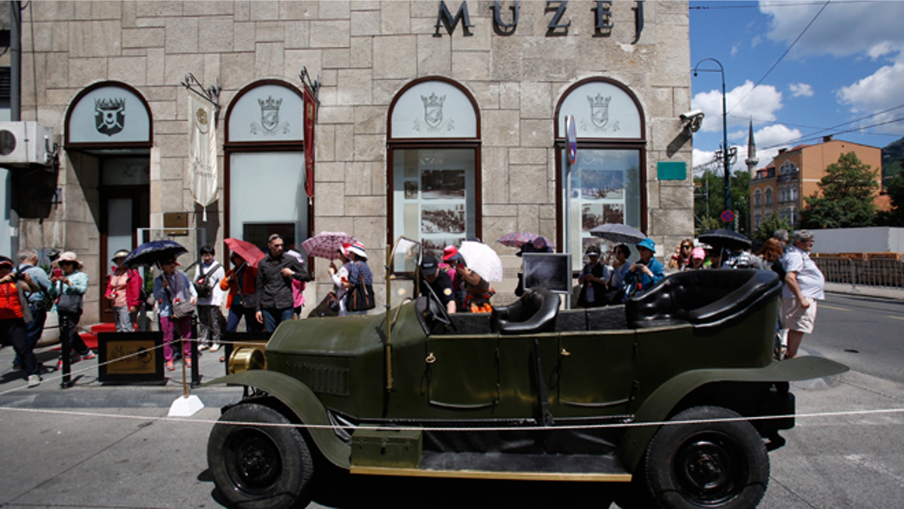 Tourists gather on Friday, June 27, 2014, around replica of the "Graf & Stift" car that Archduke Franz Ferdinand and his wife Sofia rode in as it is parked in front of museum at the historical street corner in downtown Sarajevo, where Gavrilo Princip, assassinated Austro-Hungarian heir to the throne Archduke Franz Ferdinand and his wife Sofia, on June 28, 1914. The assassination was the event that ignited the start of World War One.