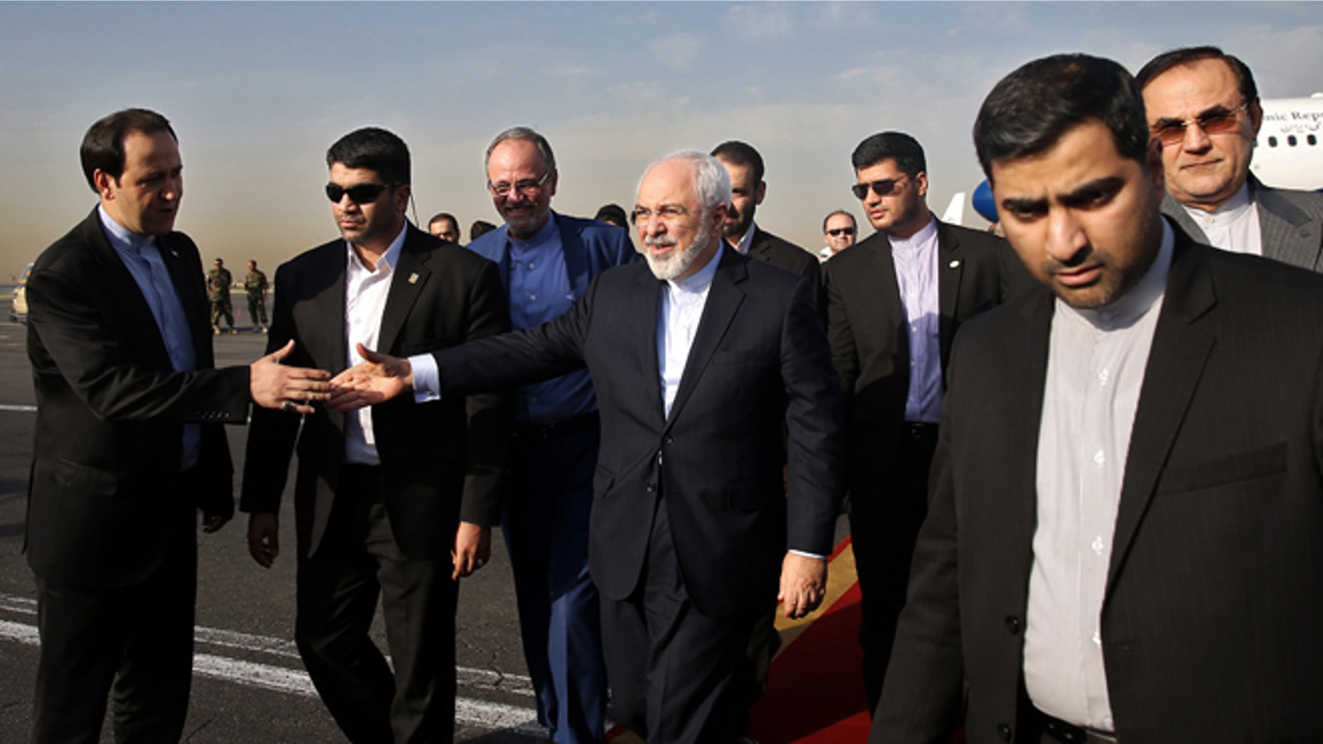 July 15, 2015: Iran's Foreign Minister Mohammad Javad Zarif, who is also Iran's top nuclear negotiator, center, shakes hands with an official upon arrival at the Mehrabad airport in Tehran, Iran. (AP Photo/Ebrahim Noroozi)