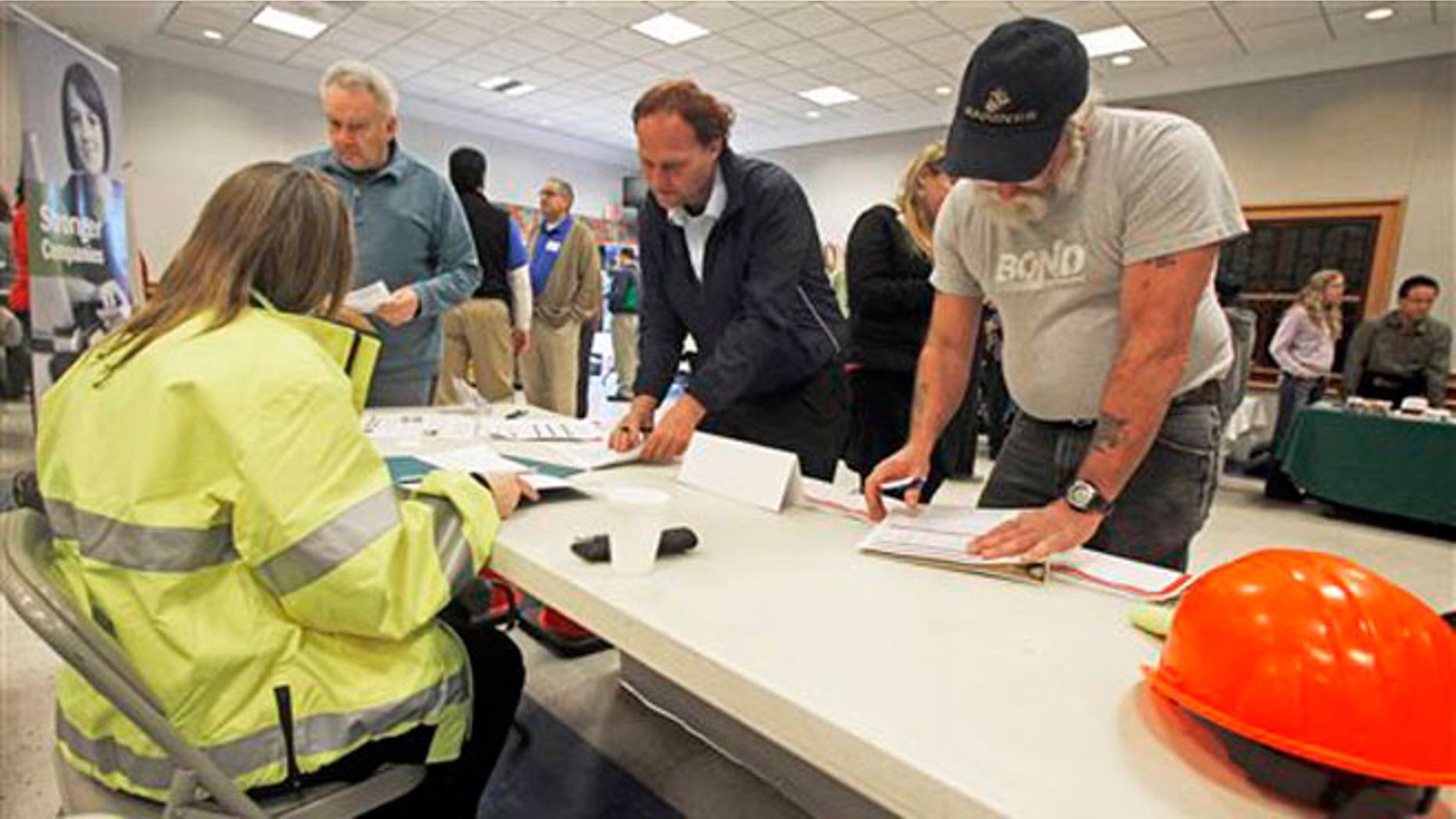 FILE -- April 3, 2013: People fill out applications at the Green Mountain Flagging table at the 4th Annual Central Vermont Job Fair in Montpelier, Vt.