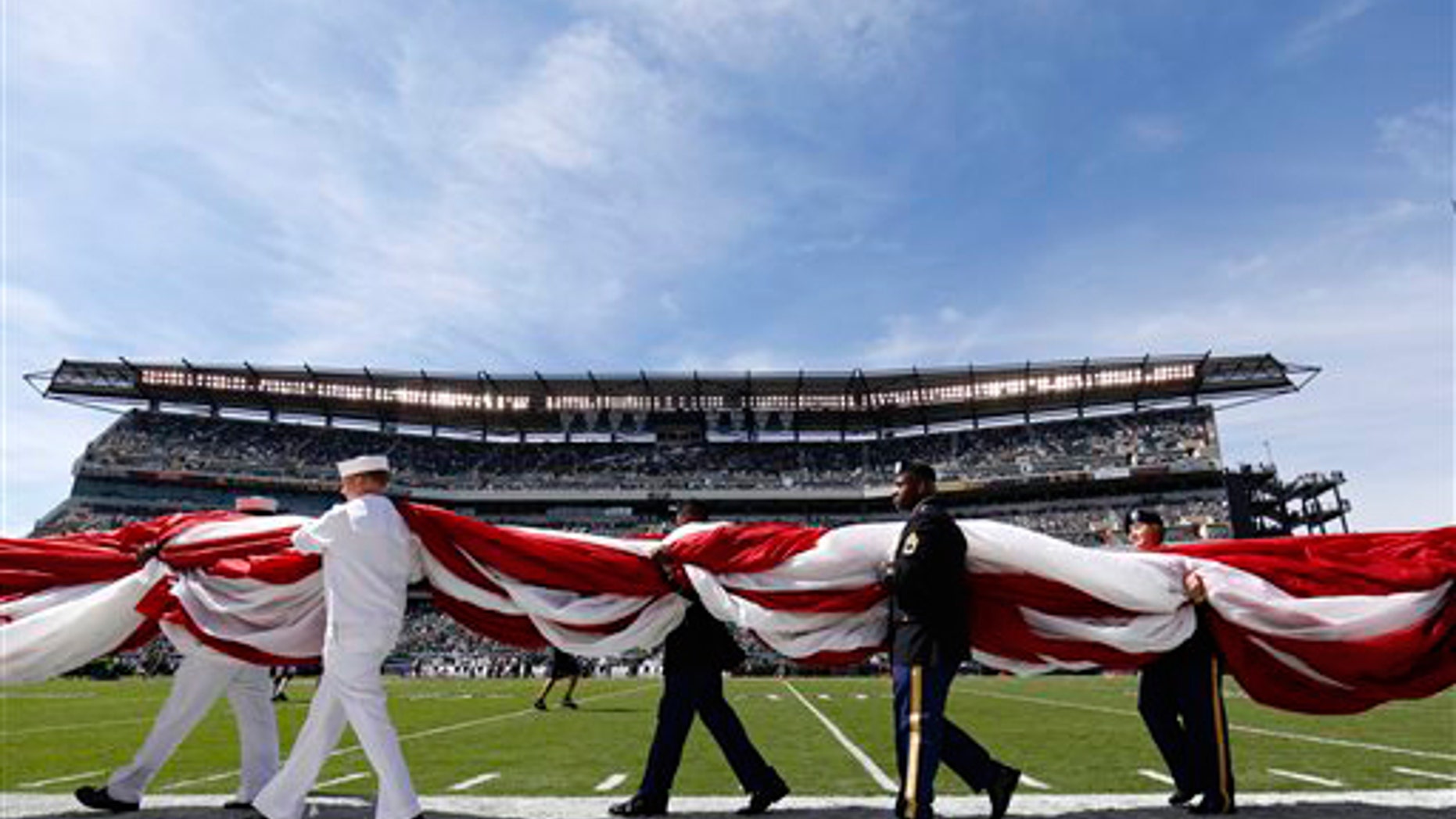 FILE -- Sept. 15, 2013: Military personnel carry an American flag on to the field before an NFL football game between the Philadelphia Eagles and the San Diego Chargers in Philadelphia.