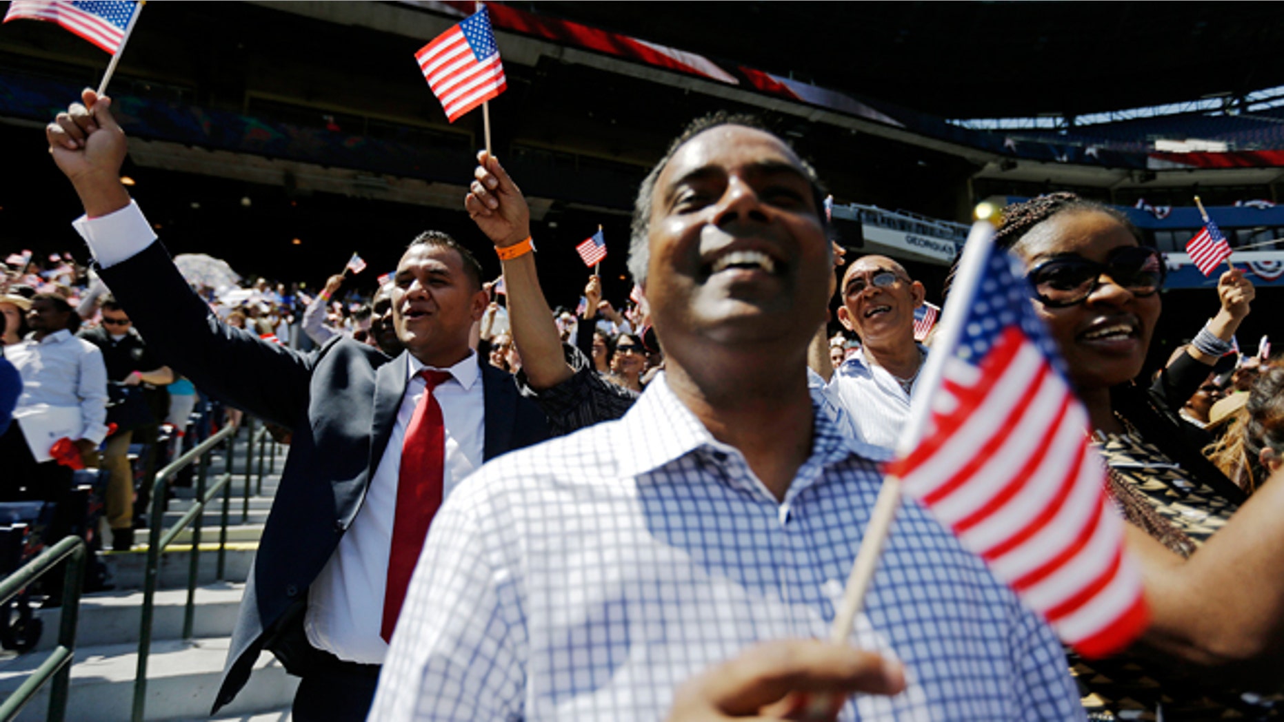 July 2, 2014: Newly-sworn in U.S. citizens cheer during a naturalization ceremony for more than 1,000 citizenship candidates at Turner Field, home of the Atlanta Braves baseball team, in Atlanta. U.S. Citizenship and Immigration Services welcomed 1,094 new citizens from 81 countries as part of their annual Independence Day celebration marking the nation’s 238th birthday this year.