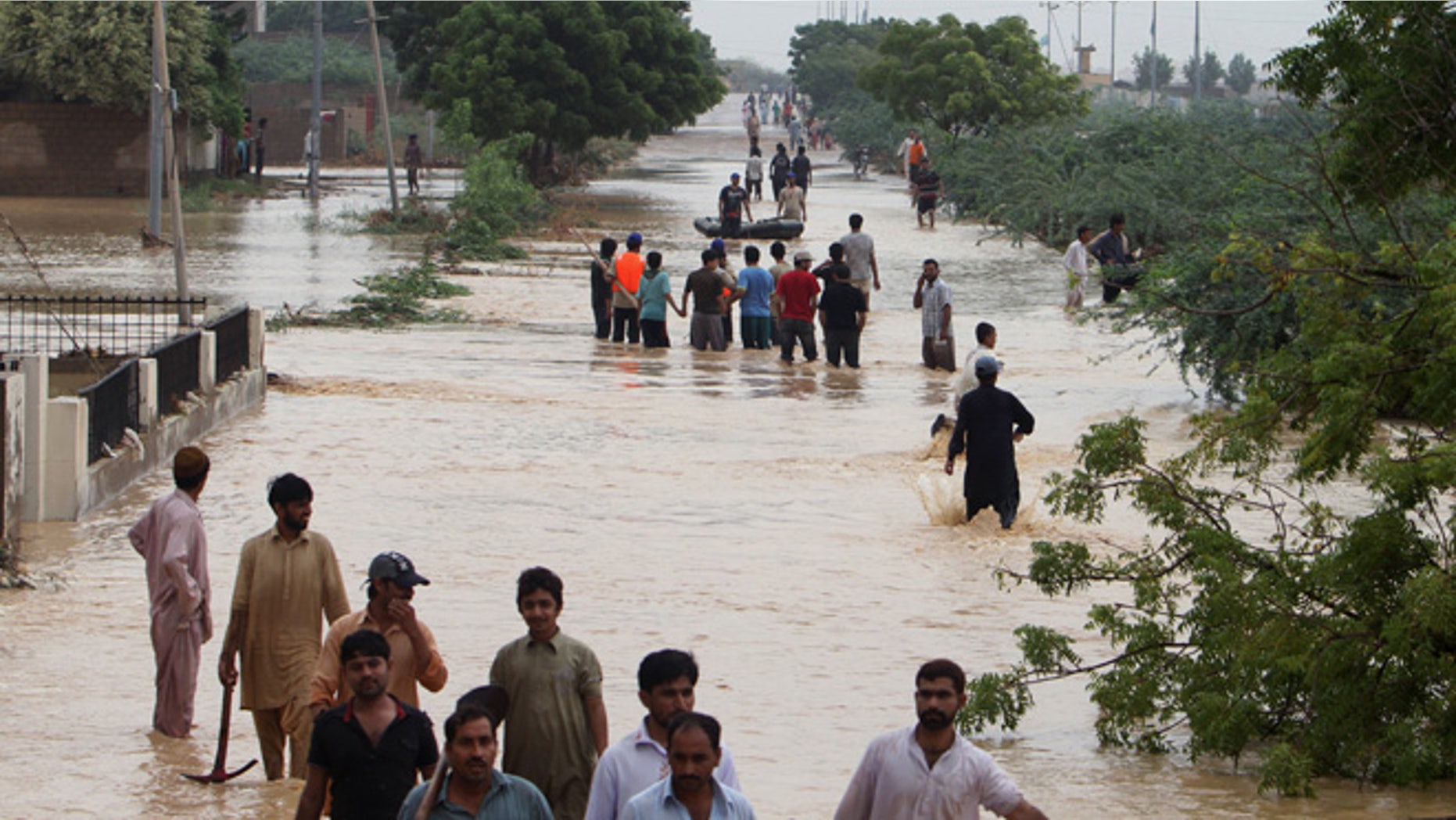 Aug. 4, 2013: People wade through flooded road caused by heavy rains on the outskirts of Karachi, Pakistan.