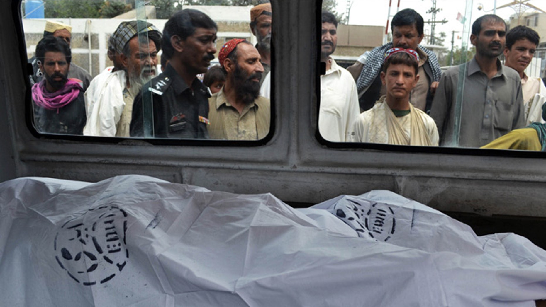 Aug. 6, 2013: People look at the lifeless bodies of victims shot by gunmen at a local hospital in Quetta, Pakistan.