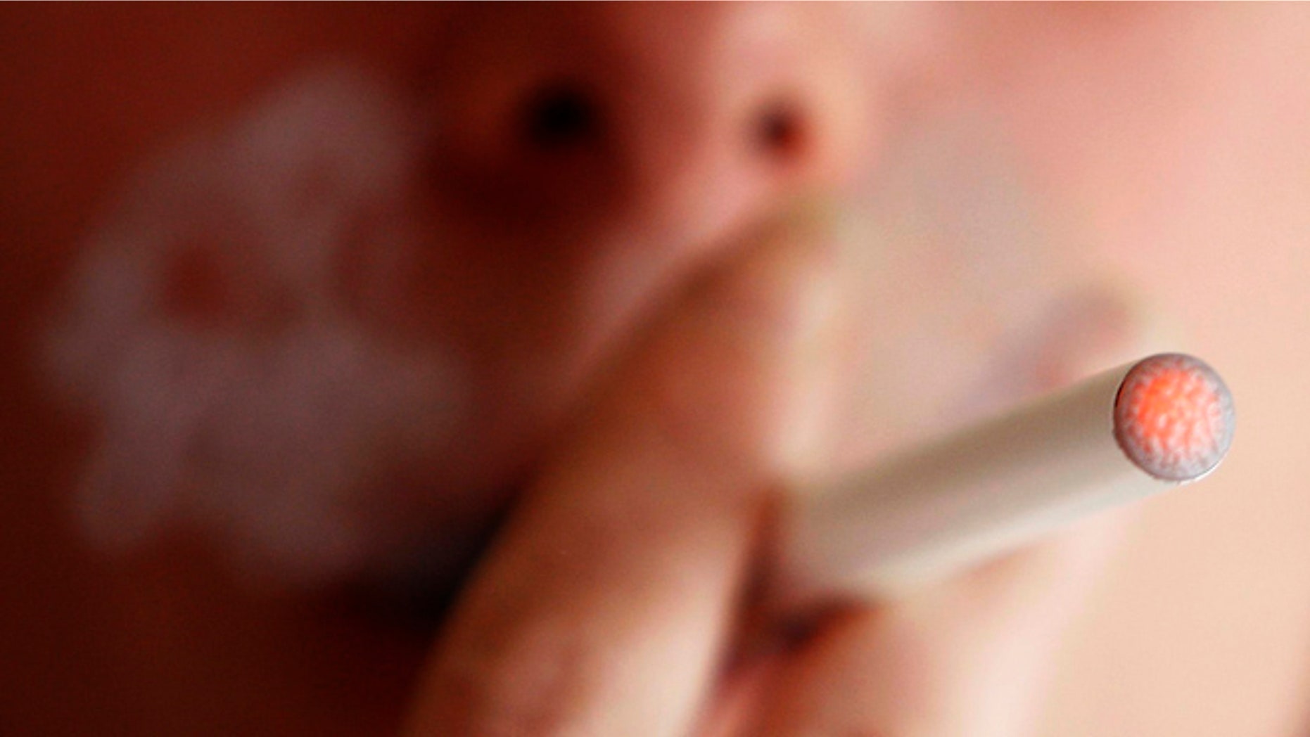 A woman smokes an E-cigarette, an electronic substitute in the form of a rod, slightly longer than a normal cigarette, in Bordeaux, southwestern France, on March 25, 2008. A changeable filter contains a liquid with nicotine and propylene glycol. When the user inhales as he would when smoking, air flow is detected by a sensor and a micro-processor activates an atomizer which injects tiny droplets of the liquid into the flowing air, producing a vapor. The E cigarette, which retails for 78 euros, is powered by a rechargeable battery. REUTERS/Regis Duvignau