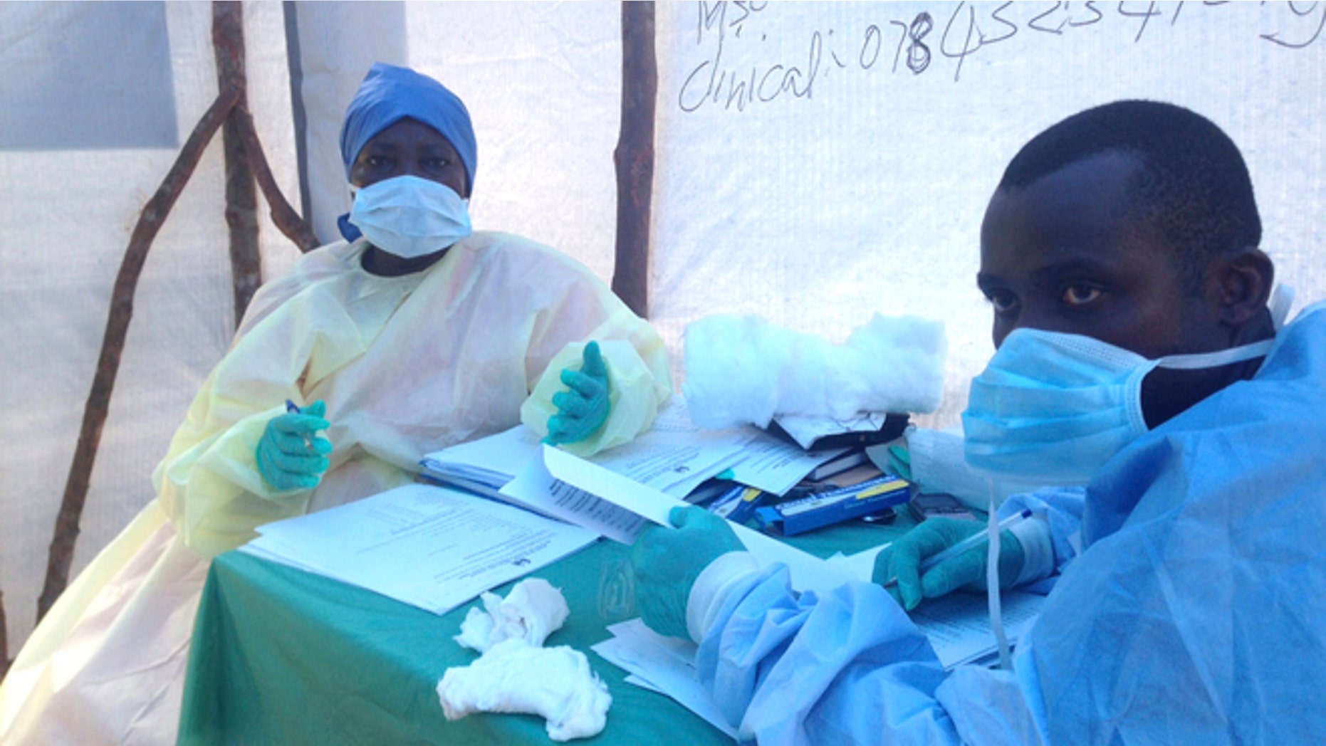 Government health workers are seen during the administration of blood tests for the Ebola virus in Kenema, Sierra Leone, June 25, 2014.