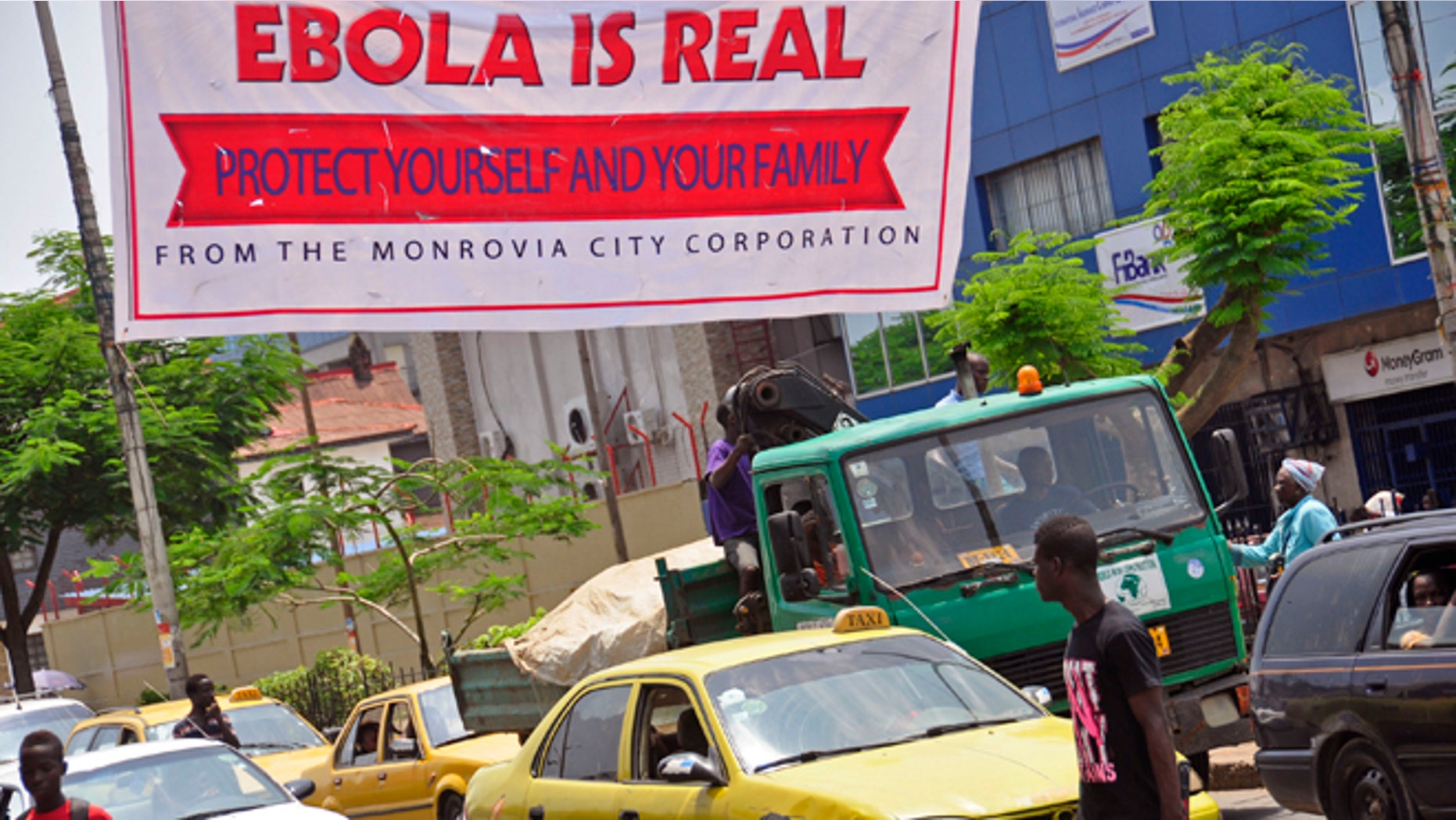 A banner reading: Ebola is real, Protect yourself and your family, warns people of the Ebola virus in Monrovia, Liberia, Saturday Aug. 2, 2014. (AP Photo/Abbas Dulleh)