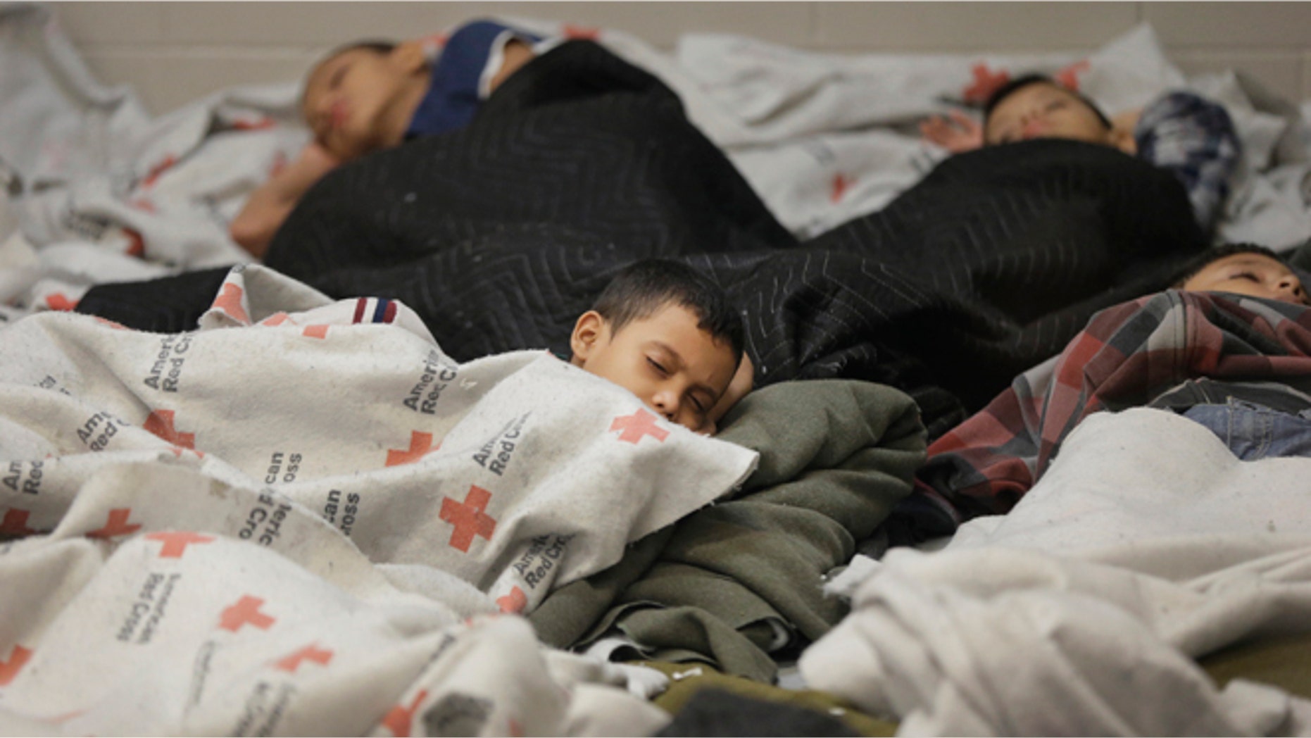 Detainees sleep in a holding cell at a U.S. Customs and Border Protection processing facility, in Brownsville, Texas June 18, 2014. CPB provided media tours June 18 of two locations in Brownsville and Nogales, Arizona that have been central to processing the more than 47,000 unaccompanied children who have entered the country illegally since Oct. 1. REUTERS/Eric Gay/Pool (UNITED STATES - Tags: CRIME LAW POLITICS SOCIETY) - RTR3UI3Q