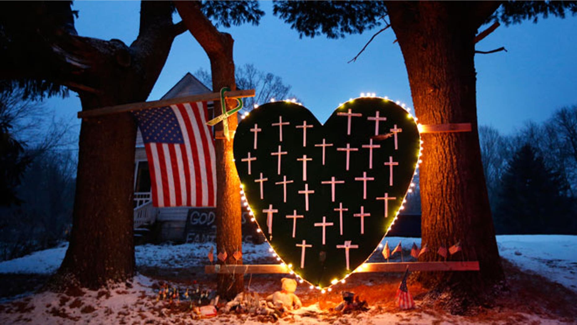 A makeshift memorial with crosses for the victims of the Sandy Hook Elementary School shooting massacre stands outside a home in Newtown, Conn., on the one-year anniversary of the shootings, Dec. 14, 2013.