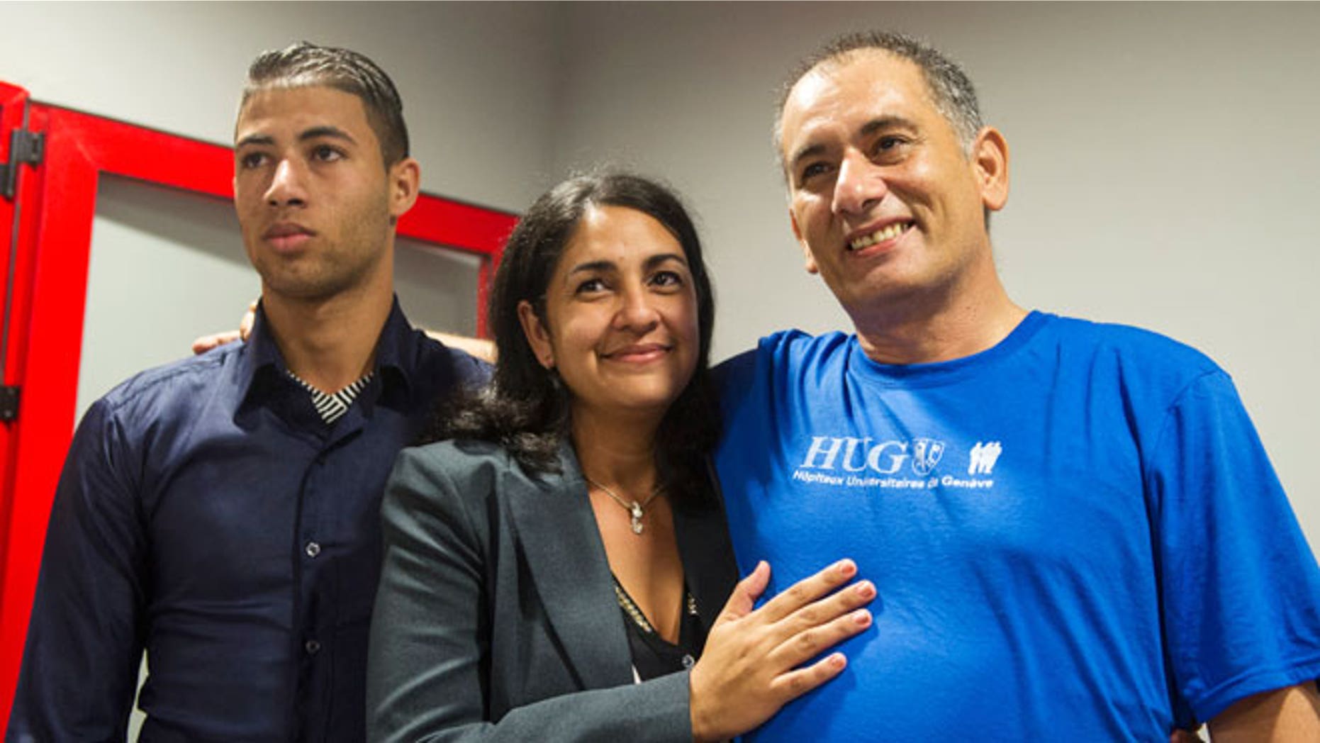 Felix Baez, a member of the International Contingent Brigade "Henry Reeve", who was infected with Ebola in Sierra Leone, poses for a photo with his wife Vania Ferrer and his son Alejandro Baez during a news conference in Havana December 6, 2014.