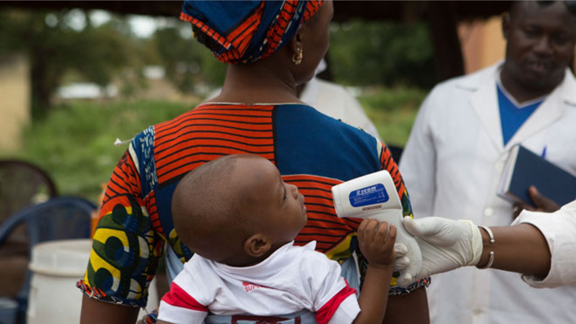 A health worker checks the temperature of a baby entering Mali from Guinea at the border in Kouremale, October 2, 2014. The worst Ebola outbreak on record was first confirmed in Guinea in March but it has since spread across most of Liberia and Sierra Leone, killing more than 3,300 people, overwhelming weak health systems and crippling fragile economies.