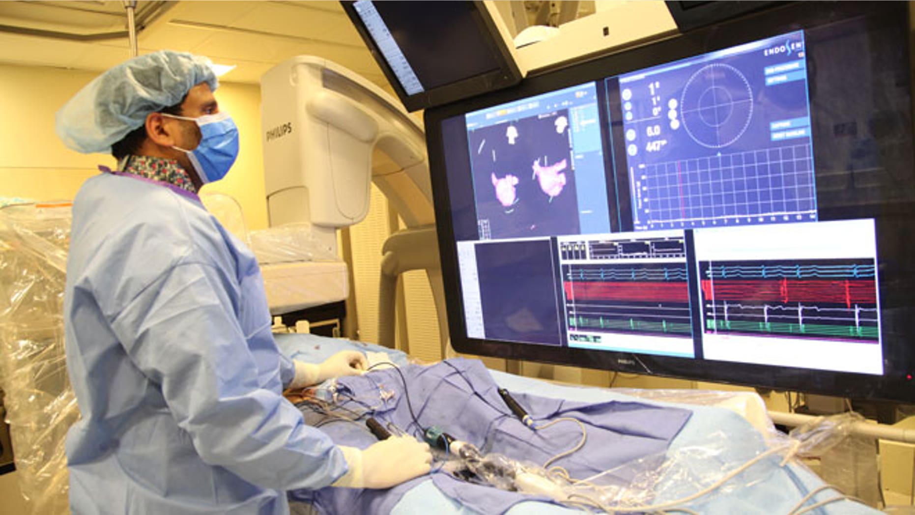 In this undated image provided on Saturday Aug. 29, 2015 by Mount Sinai Hospital in New York shows Dr Vivek Reddy as he checks the screen while doing a surgery to implant the new tiny wireless pacemaker at the Mount Sinai hospital in New York . Unlike traditional pacemakers — which need a generator and wires and are implanted via surgery — the new pacemaker is a wireless tiny tube that can be attached to the right side of the heart using a catheter inserted through the leg.