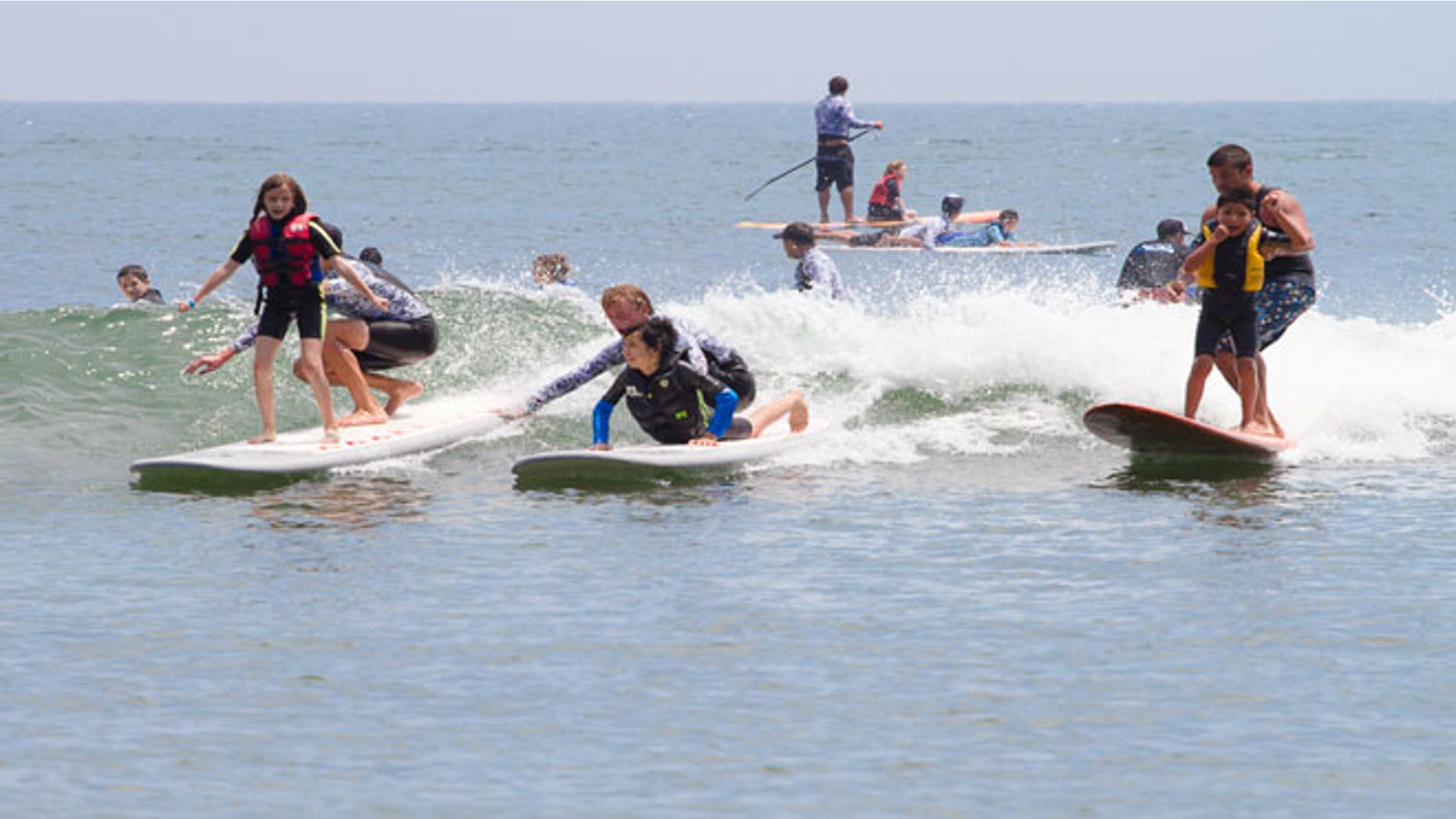 Campers and Surfers Healing volunteers catch a wave in 2013 in Malibu, Calif.