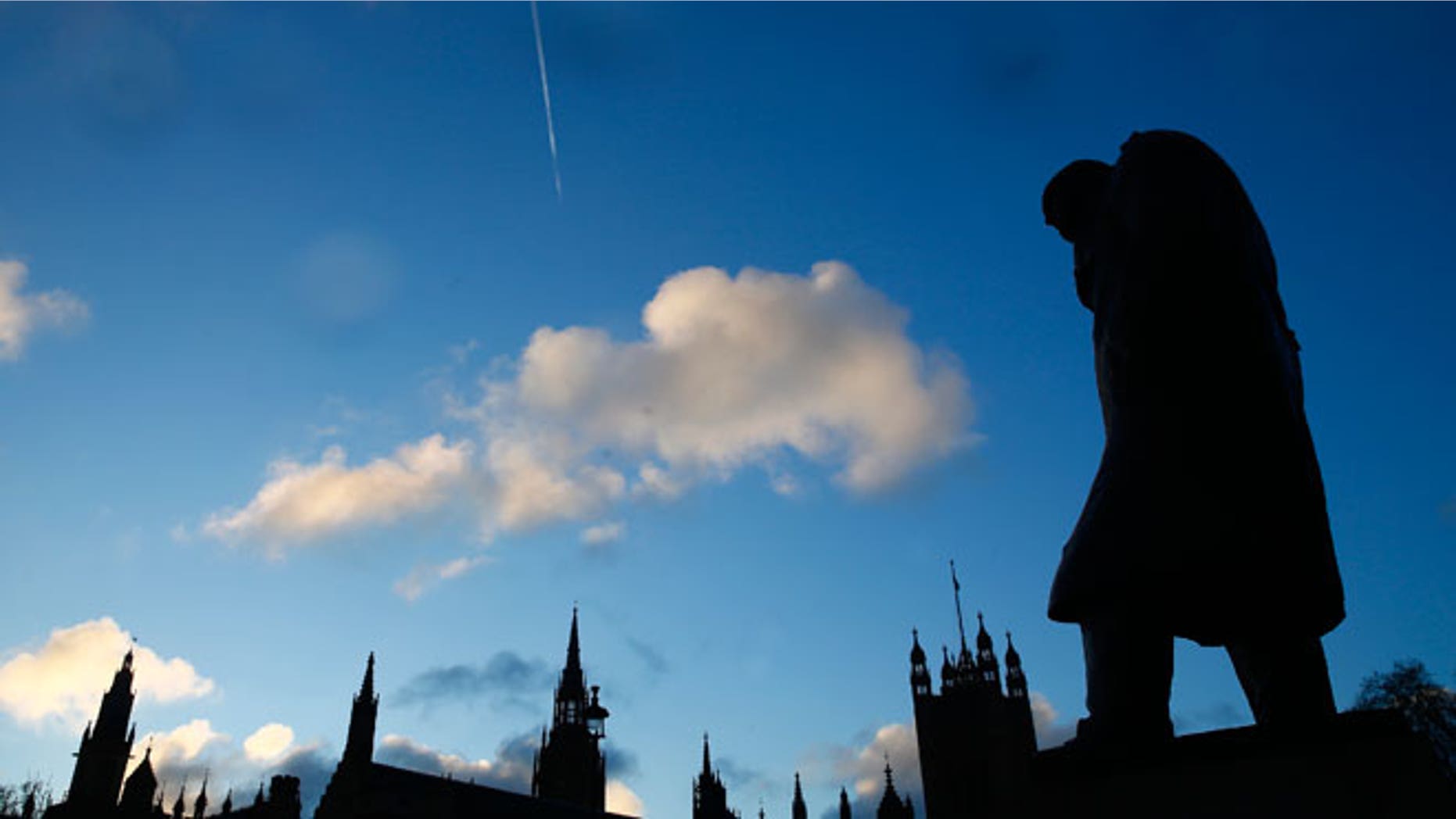 The statue of Britain's former Prime Minister Winston Churchill is silhouetted in front of the Houses of Parliament in London, January 30, 2015.