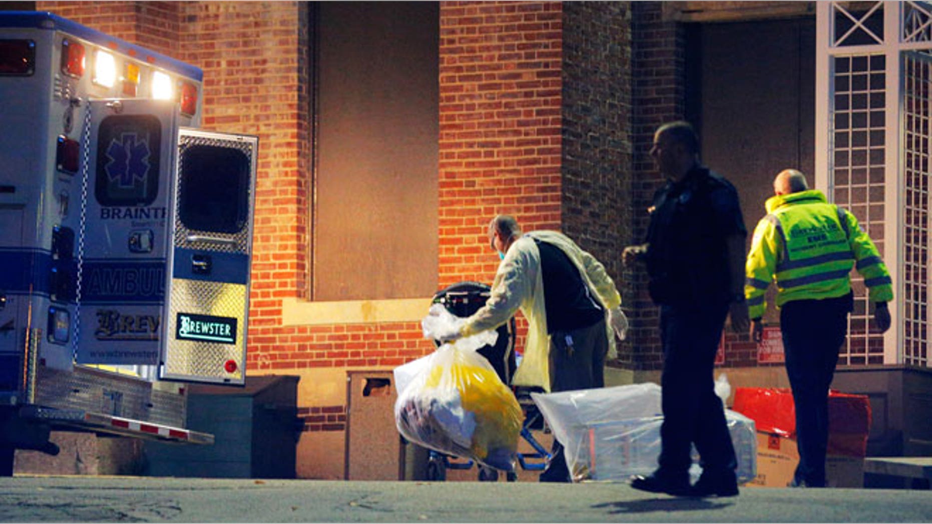 A man collects and bags items behind the ambulance used to transport a patient with possible Ebola symptoms to Beth Israel Deaconess Medical Center in Boston, Massachusetts October 12, 2014. A patient in Massachusetts who recently returned from Liberia and was displaying symptoms of Ebola was transferred from a medical clinic to a Boston hospital on Sunday, the hospital said. The patient has not been confirmed to have the deadly virus. REUTERS/Brian Snyder