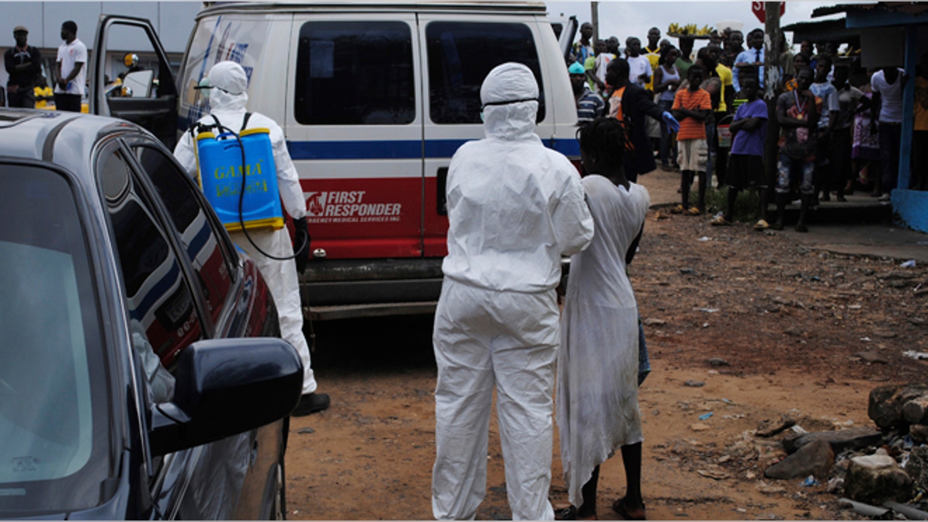 Health workers bring a woman suspected of having contracted Ebola virus to an ambulance in front of a crowd in Monrovia, Liberia, September 15, 2014. Airlines have halted many flights into and around West Africa, where governments have closed some borders and imposed travel restrictions in a bid to fight an Ebola outbreak that has killed over 2,400 people. REUTERS/James Giahyue (LIBERIA - Tags: DISASTER HEALTH) - RTR46CG3