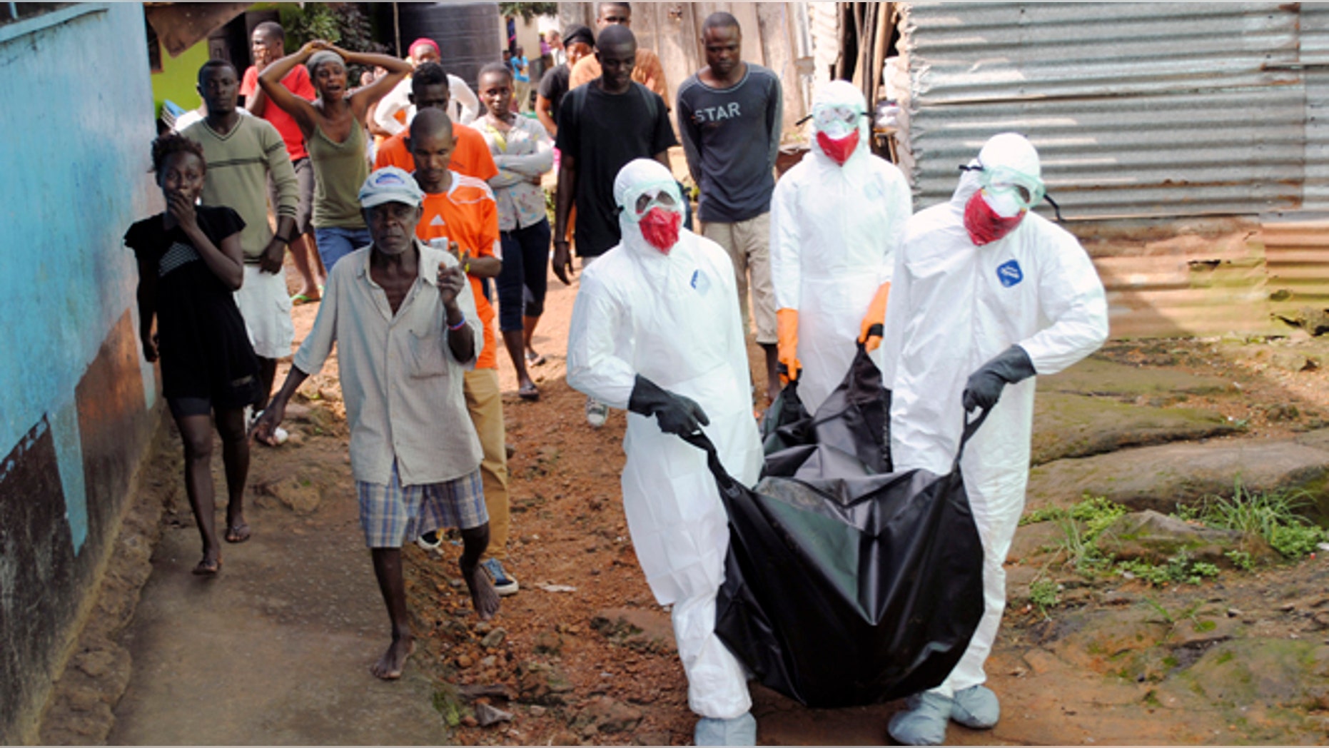 Health workers remove the body of Prince Nyentee, a 29-year-old man whom local residents said died of Ebola virus in Monrovia September 11, 2014. REUTERS/James Giahyue (LIBERIA - Tags: DISASTER HEALTH TPX IMAGES OF THE DAY) - RTR45VJ6