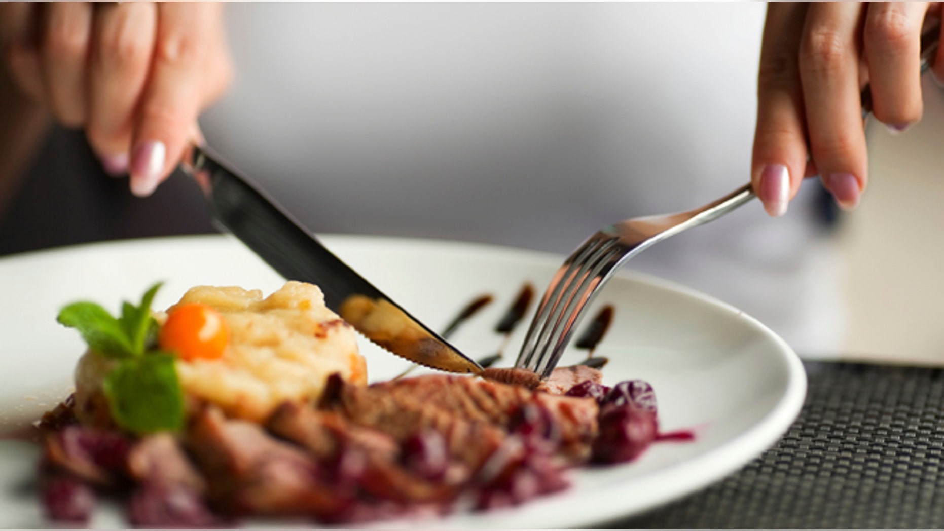 Female hands with a dinner at restaurant.