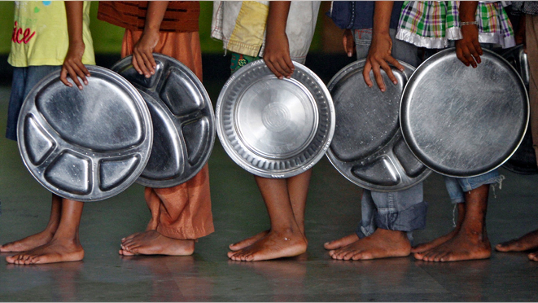 Children holding plates wait in a queue to receive food at an orphanage run by a non-governmental organisation on World Hunger Day, in the southern Indian city of Chennai May 28, 2014. REUTERS/Babu (INDIA - Tags: SOCIETY) - RTR3R82F