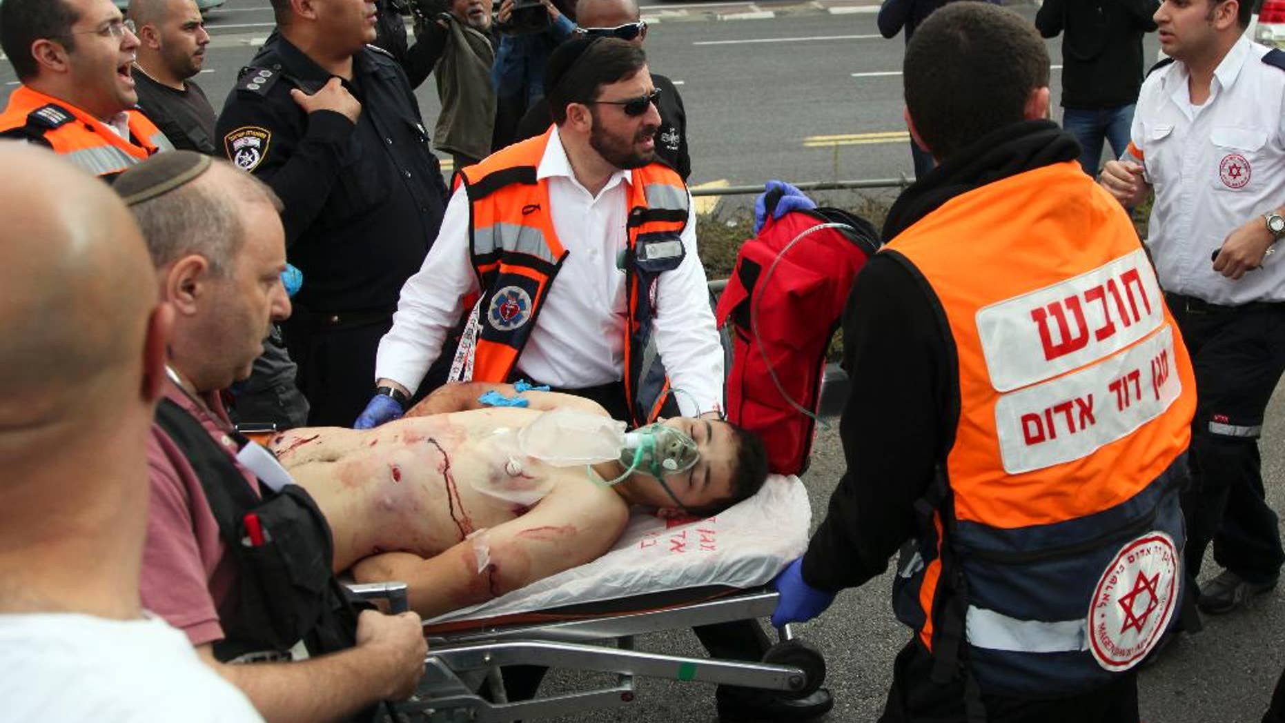 Paramedics evacuate a wounded Palestinian attacker in Jerusalem on Friday, Oct. 30, 2015. The Palestinian stabbed and seriously wounded a man at a station of Jerusalem's light rail Friday before he was shot and wounded by Israeli forces, police said. (AP Photo/Mahmoud Illean)