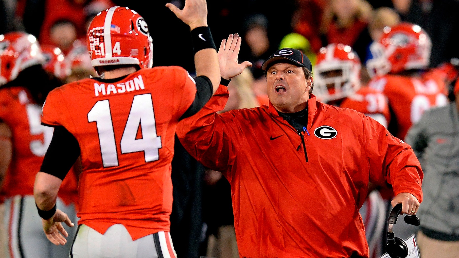 Georgia quarterback Hutson Mason (14) and defensive coordinator Todd Grantham celebrate a Georgia interception against Georgia Tech during the second half of an NCAA football game on Saturday, Nov. 30, 2013, in Atlanta. Georgia won 41-34 in double overtime when Georgia Tech failed to score. (AP Photo/David Tulis)