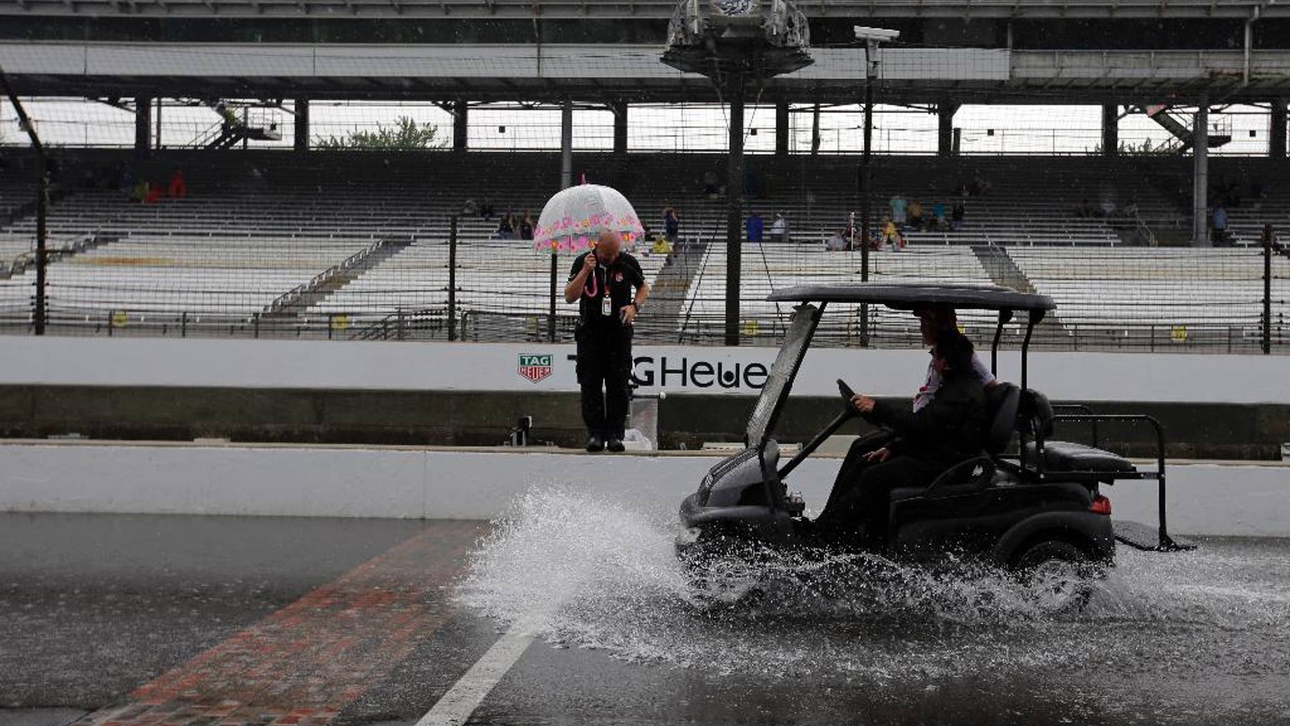 A cart splashes up water as its crosses the start/finish line as rain closed the track on the first day of qualifications for the Indianapolis 500 auto race at Indianapolis Motor Speedway in Indianapolis, Saturday, May 16, 2015. (AP Photo/Darron Cummings)