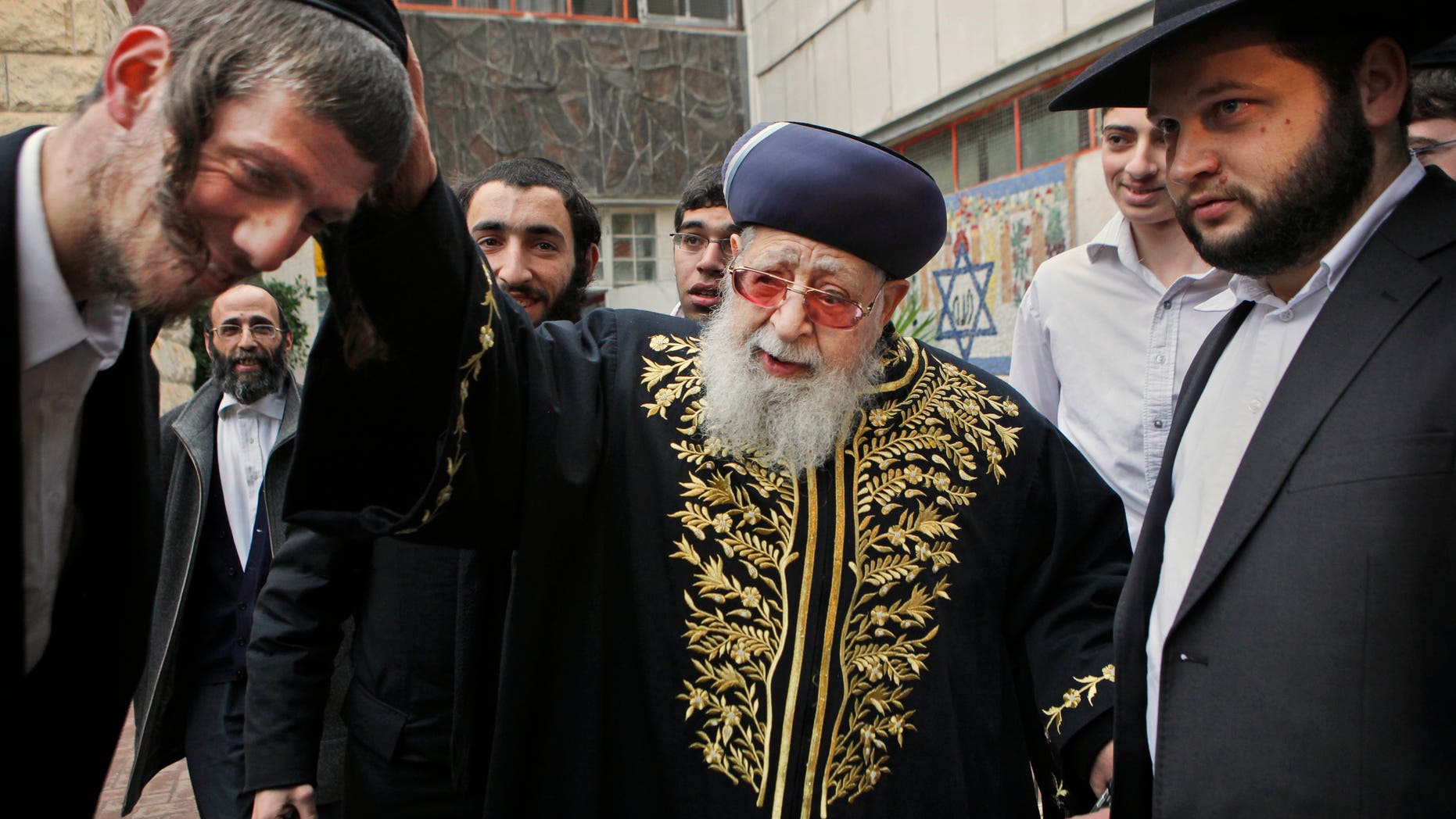 FILE - In this Feb. 10, 2009 file photo, Rabbi Ovadia Yosef, center, Jewish spiritual leader of Israel's Shas party, blesses a man after casting his ballot at a polling station in Jerusalem. An Israeli health official said Saturday Jan. 12, 2013, that influential Yosef has been hospitalized after feeling unwell. (AP Photo/Kevin Frayer, File)