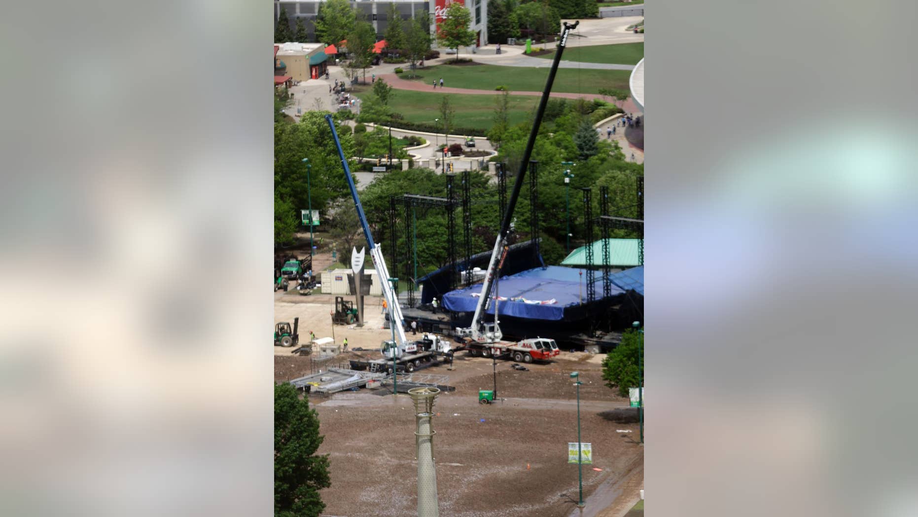 Construction workers take down a stage in Centennial Olympic Park after patrons attending a festival turned the grass to mud during a rain storm, Monday, April 20, 2015, in Atlanta. Park officials couldn't immediately be reached, but a recorded message states that the park would be closed Monday for cleanup after the SweetWater 420 Fest. (AP Photo/Mike Stewart)
