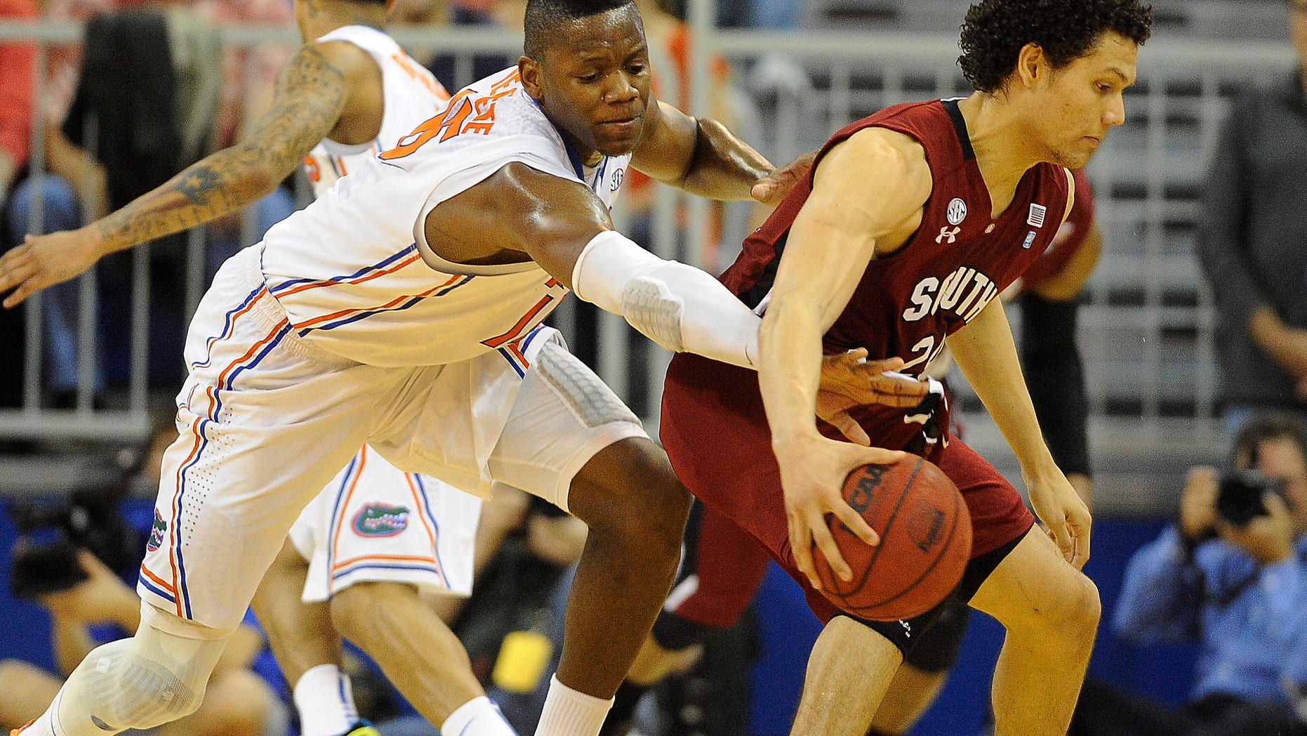 Florida forward Will Yeguete (15) tries to knock the ball out of the hands of South Carolina's Michael Carrera (24) during the first half of an NCAA college basketball game in Gainesville, Fla., Wednesday, Jan. 30, 2013. (AP Photo/Phil Sandlin)