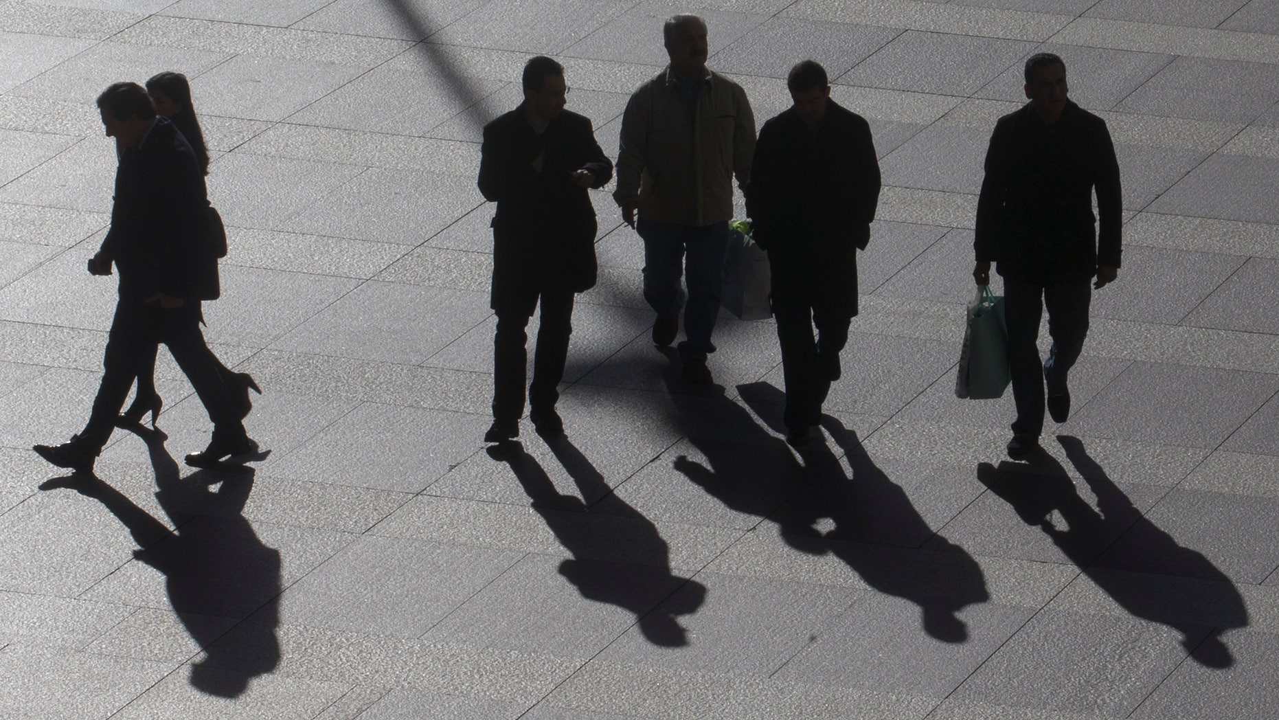 Office workers walk in the business district of Madrid, Tuesday Jan. 15, 2013. Spain has sold an above-target euro 5.8 billion ($7.74 billion) in short-term bills at a sharply reduced interest rate, reflecting easing investor concern over the country's ability to manage its finances without a bailout. Spain's borrowing costs have plunged from unsustainable highs last year after the European Central Bank pledged to help countries by buying up their short-term bonds if they apply for help. Spain says it does not need outside aid for the moment.(AP Photo/Paul White)