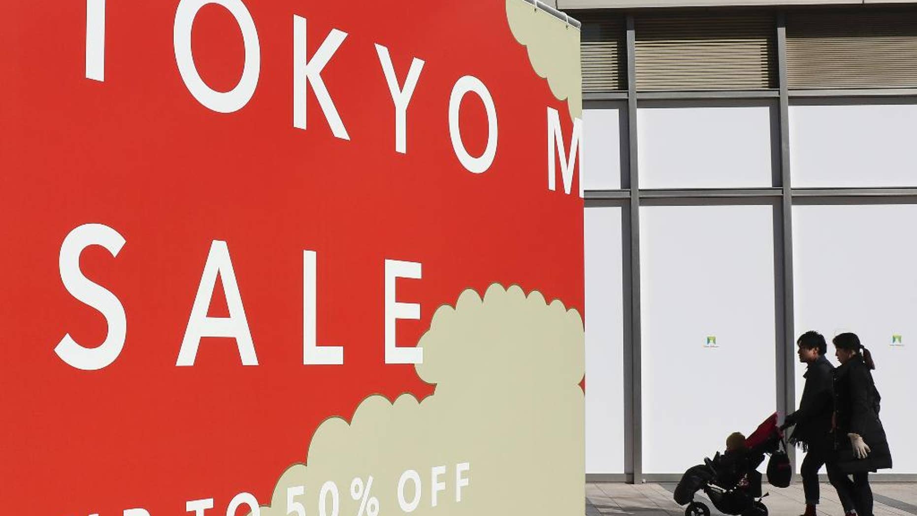 In this Jan. 15, 2017, photo, a couple pushes a baby buggy at Tokyo's Roppongi district. Japan's economy expanded at a slightly slower than expected 1.0 percent annual pace in 2016, helped by an uptick in exports, the Cabinet office reported Monday, Feb. 13, 2017. The world's third-largest economy grew 0.2 percent in the last quarter, from the previous quarter, according to preliminary data, the slowest pace for the year. (AP Photo/Shizuo Kambayashi)