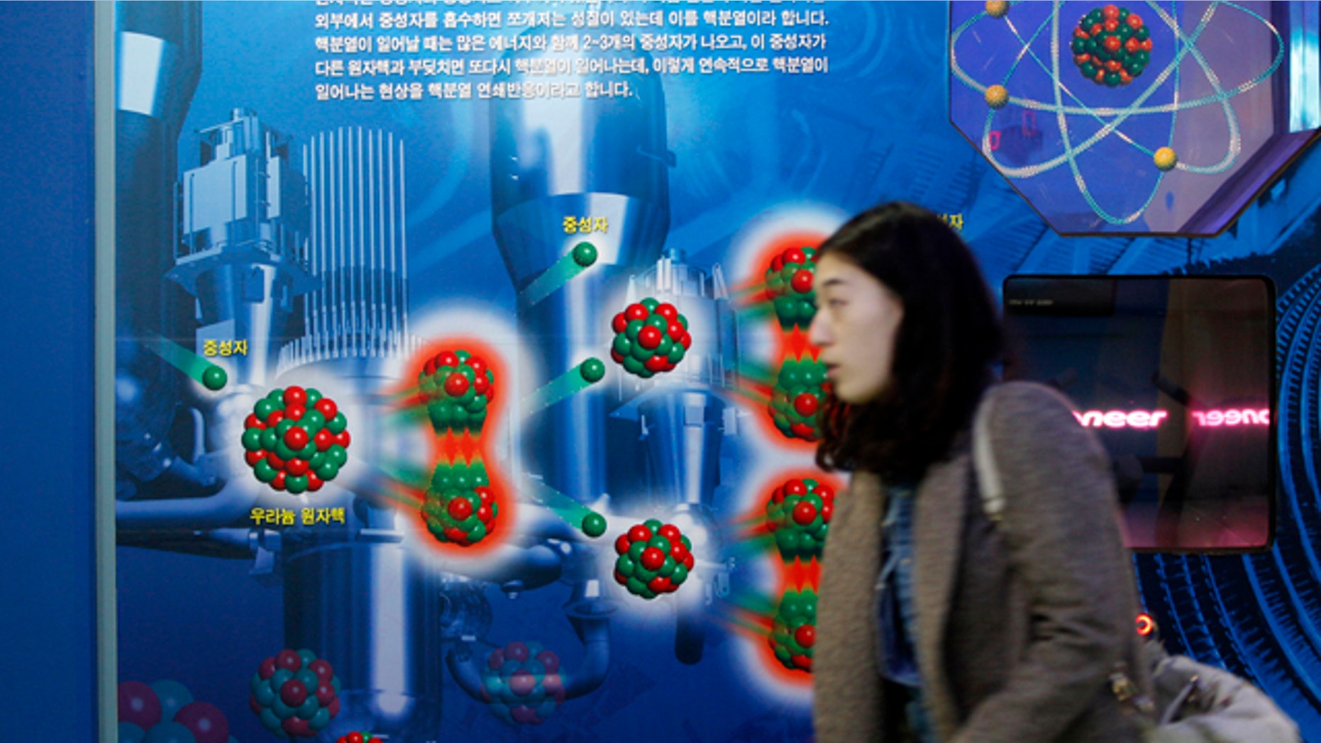 Nov. 30: A South Korean woman walks near a diagram showing the theory of uranium atomic nucleus at the Seoul Science Park.