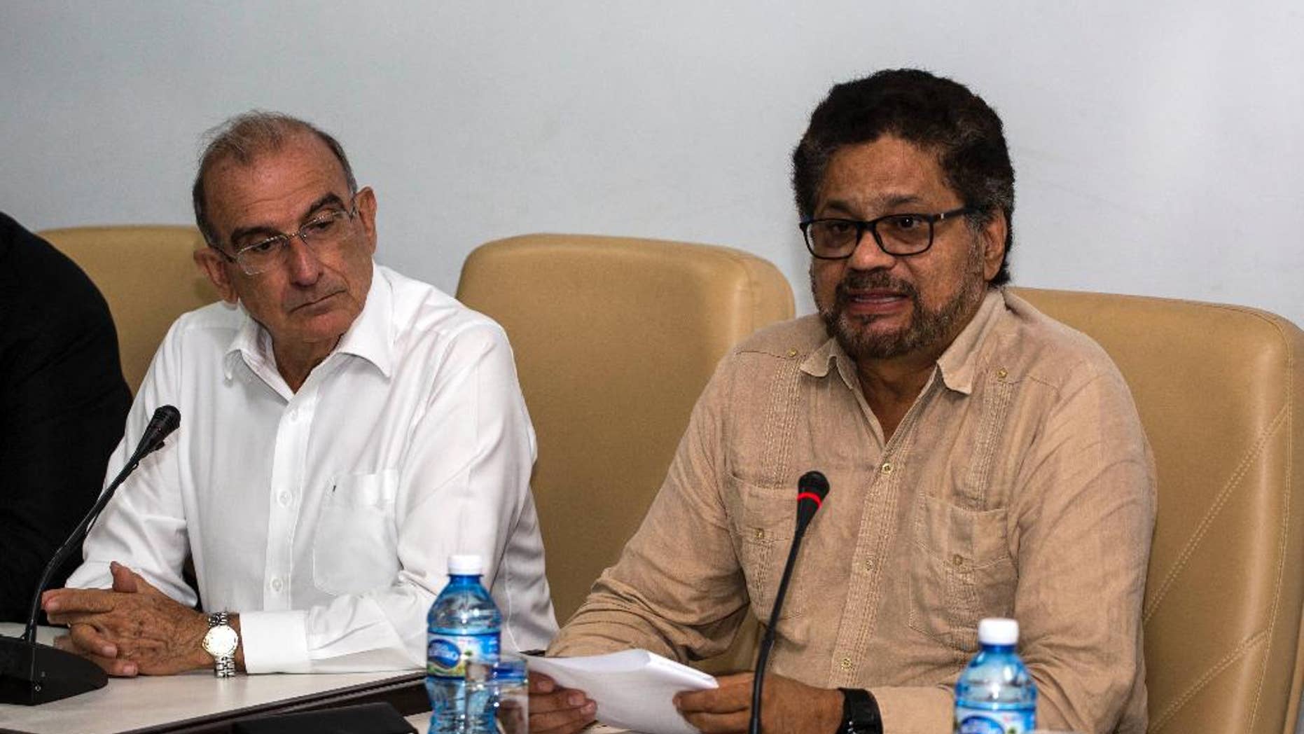 Humberto de La Calle, left, head of Colombia's government peace negotiation team, listens as Ivan Marquez, chief negotiator of the Revolutionary Armed Forces of Colombia (FARC) reads a joint statement in Havana, Cuba, Friday, Oct. 28, 2016. The statement said many new proposals have been incorporated in the text of a new peace accord after voters narrowly defeated the deal on Oct. 2. (AP Photo/Desmond Boylan)