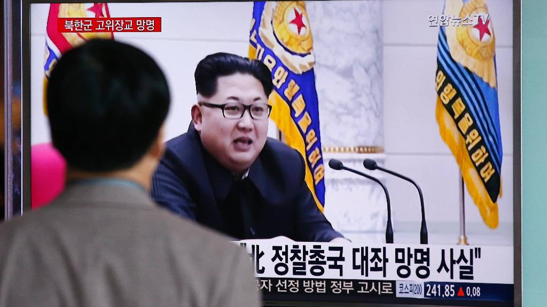 A man watches a TV news program showing file footage of North Korean leader Kim Jong Un at Seoul Railway Station in Seoul, South Korea, Monday, April 11, 2016. A colonel from North Korea's military spy agency fled to South Korea last year in a rare senior-level defection, Seoul officials said Monday. The letters read "True, A colonel from North Korean military's General Reconnaissance Bureau Asylum." (AP Photo/Lee Jin-man)