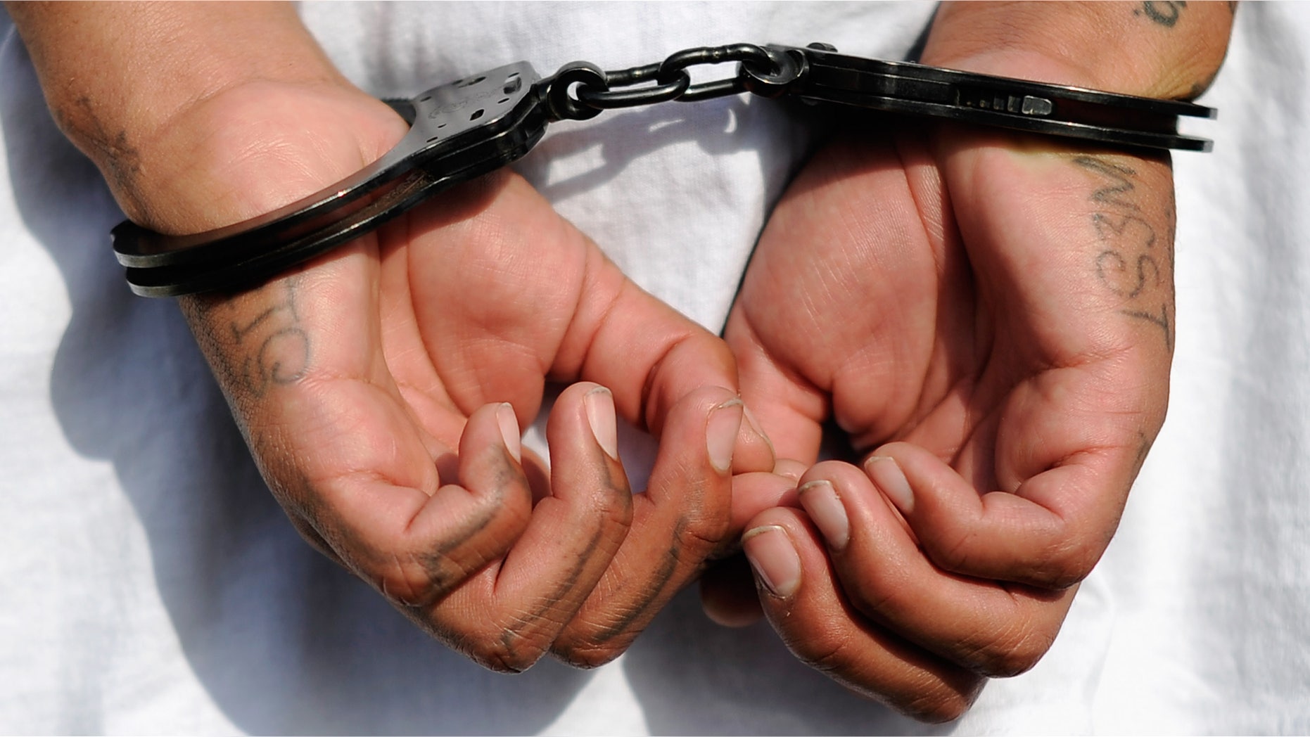 LOS ANGELES, CA - APRIL 29: Handcuffs are seen on the hands of a twenty-year old "Street Villains" gang member who was arrested by Los Angeles Police Department officers from the 77th Street division on April 29, 2012 in Los Angeles, California. The 77th Street division patrol the same neighborhood that truck driver Reginald Denny was nearly beaten to death by a group of black assailants at the intersection of Florence and Normandie Avenues. It?s been 20 years since the verdict was handed down in the Rodney King case that sparked infamous Los Angeles riots. (Photo by Kevork Djansezian/Getty Images)