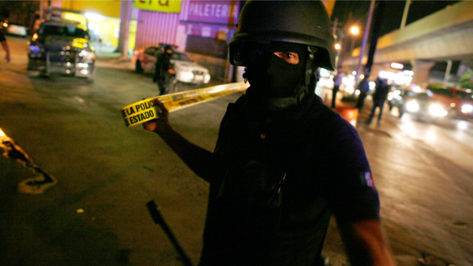 File photo. June 11, 2010: A Mexican policeman cordons off a crime scene.