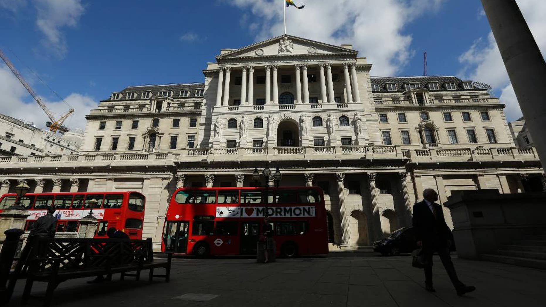FILE - In this Friday, June, 24, 2016 file photo, Buses pass the Bank of England, in the City of London. Britain's leading stock index has struck a record high as a closely monitored survey showed manufacturers in the country expanding at their highest tick in 30 months. By late-morning Tuesday, Jan. 3, 2017 the FTSE 100 index was up 0.3 percent at 7,165. Earlier in the session, it had breached the 7,200 mark for the first time ever, trading as high as 7,205.21. (AP Photo/Matt Dunham, File)