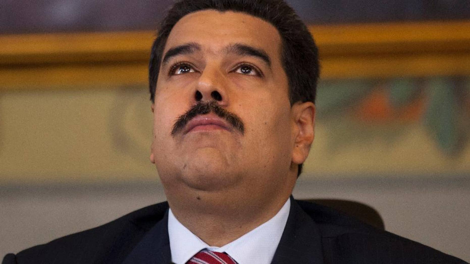 FILE - In this Oct. 15, 2014 file photo, Venezuela's President Nicolas Maduro looks up, minutes before the start of a press conference at Miraflores presidential palace in Caracas, Venezuela. Maduro used decree powers Tuesday, Nov. 18, 2014, to put in place 28 new measures, including a luxury tax, increased protection for young workers, and the establishment of new economic development zones. (AP Photo/Ariana Cubillos, File)