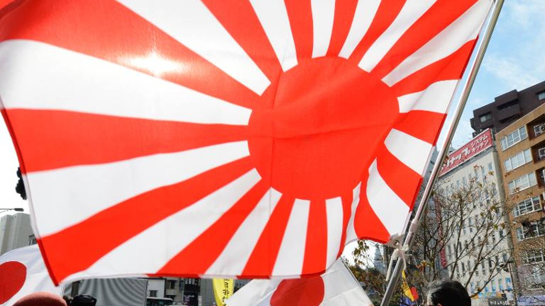 Members of a nationalist group hold a "Rising Sun" flag at a rally in Tokyo on February 22, 2013 over the disputed Takeshima/Dokdo islands