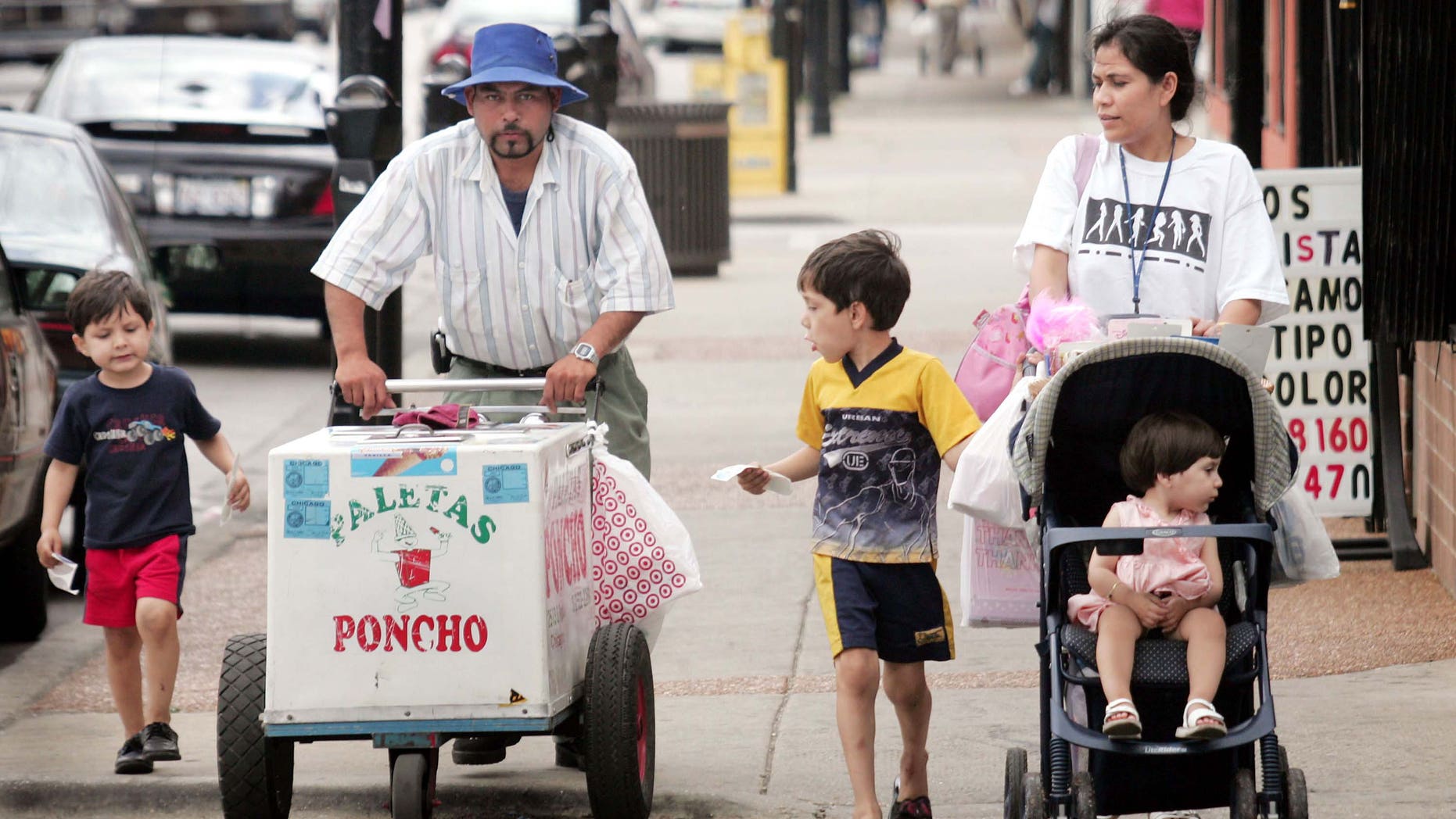 CHICAGO - JUNE 14: Residents walk past a paleta vendor along 26th Street in the predominantly Mexican Little Village neighborhood June 14, 2005 in Chicago, Illinois. According to the U.S. census Hispanics accounted for approximately half of the national population growth between July 1, 2003 and July 1, 2004 now accounting for one-seventh of the population. (Photo by Scott Olson/Getty Images)