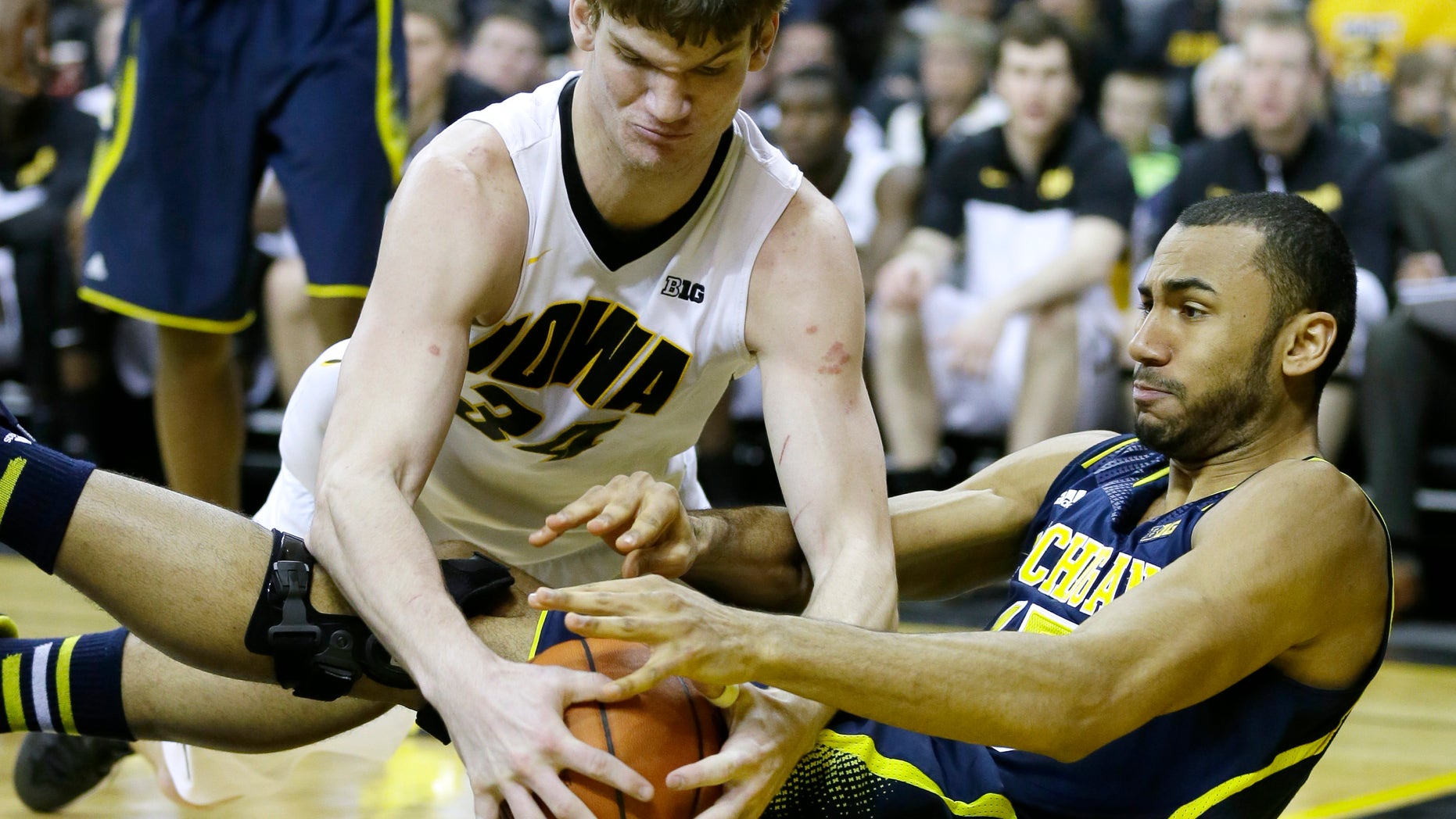 Iowa center Adam Woodbury, left, fights for a loose ball with Michigan forward Jon Horford during the second half of an NCAA college basketball game, Saturday, Feb. 8, 2014, in Iowa City, Iowa. Iowa won 85-67. (AP Photo/Charlie Neibergall)